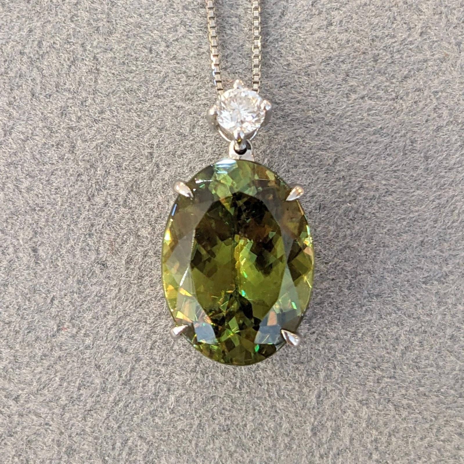 Collier pendentif en platine avec sphène ovale et diamant rond de 5,69 ct 

Le collier pendentif comprend une Brilliante ovale de 5,69 carats de couleur verte multicolore, sertie et rehaussée d'un diamant rond brillant dans une monture en platine