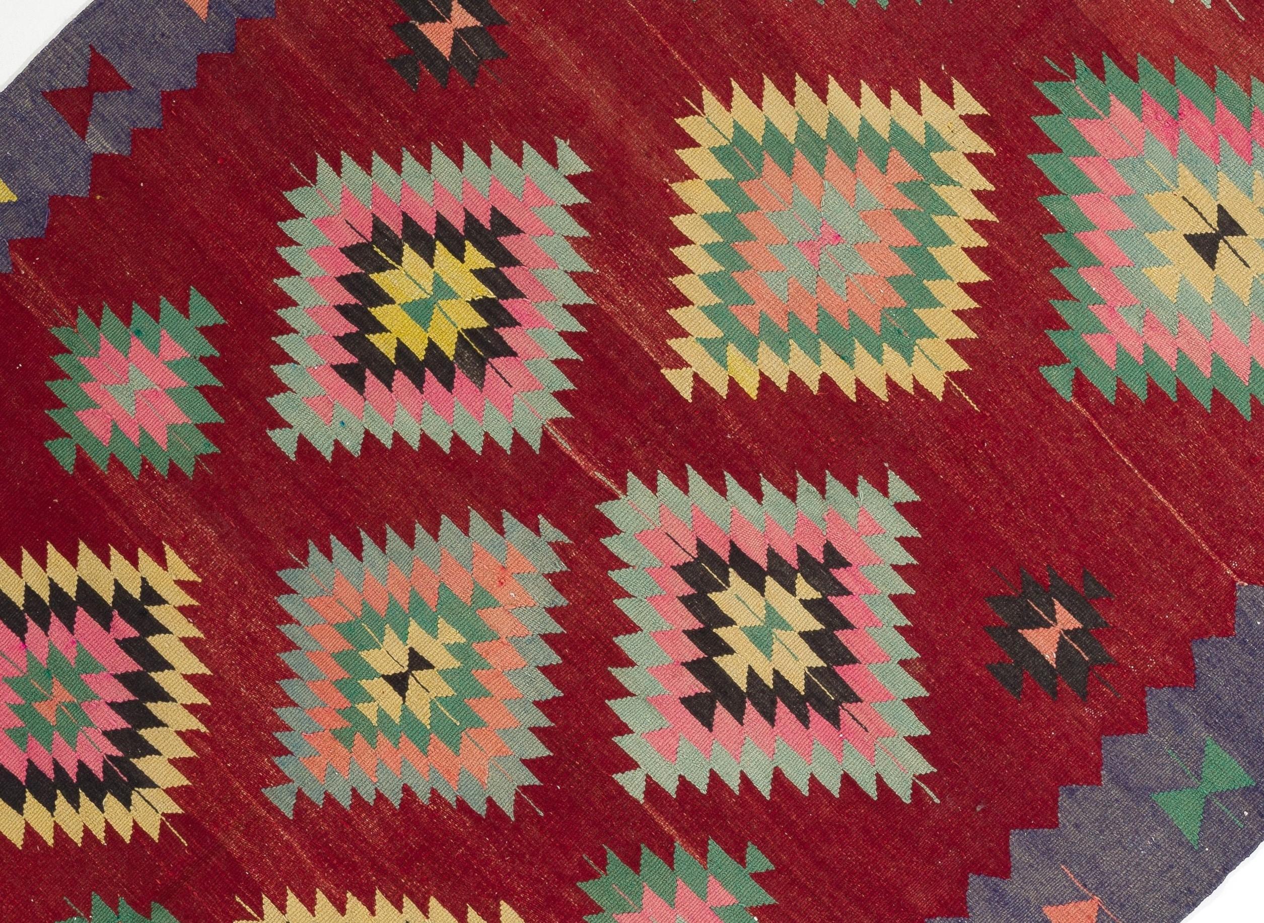 Un kilim vintage coloré de l'ouest de la Turquie. Un tapis tissé à la main en laine, à tissage plat, en très bon état. 

Ce Kilim captivant présente des motifs de diamants échelonnés, nichés les uns dans les autres, flottant librement sur tout le