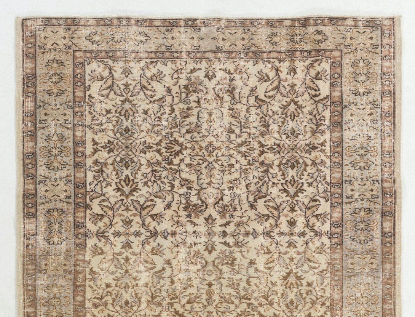 A vintage Turkish area rug in beige and brown colors. It was hand-knotted in the 1960s and all-over floral design. Low wool pile on finely woven cotton foundation. Sturdy and can be used on a high traffic area, suitable for both residential and