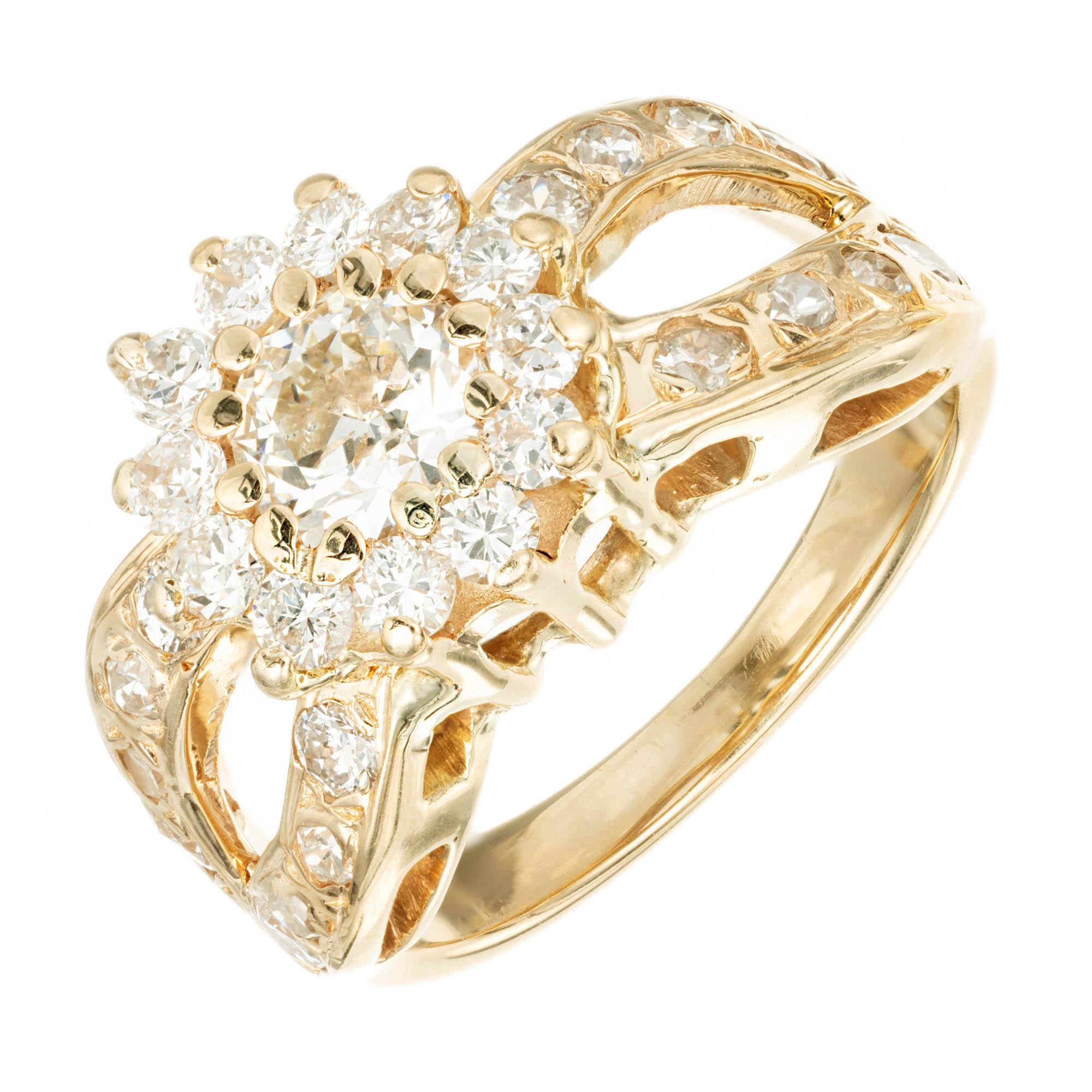 Diamond Halo Center with pave diamond set infinity loops across a 14k Yellow Gold engagement ring. 

1 round brilliant cut L VS Diamond, Approx. .52 carat
12 round brilliant cut H-I VS diamonds, Approx. .48 carats 
16 round brilliant cut and single