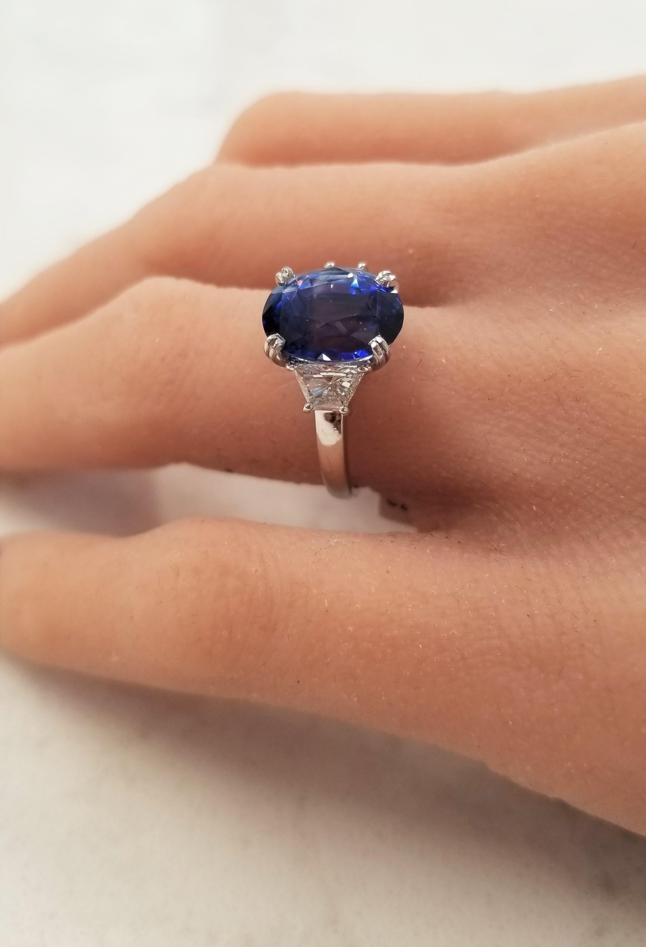 The spotlight is the 5.70 carat elongated cushion cut blue sapphire. The gem source is Sri Lanka; its color is royal blue; its transparency and luster is superb. The color is alluring and is evenly distributed throughout the gem. Two step-cut