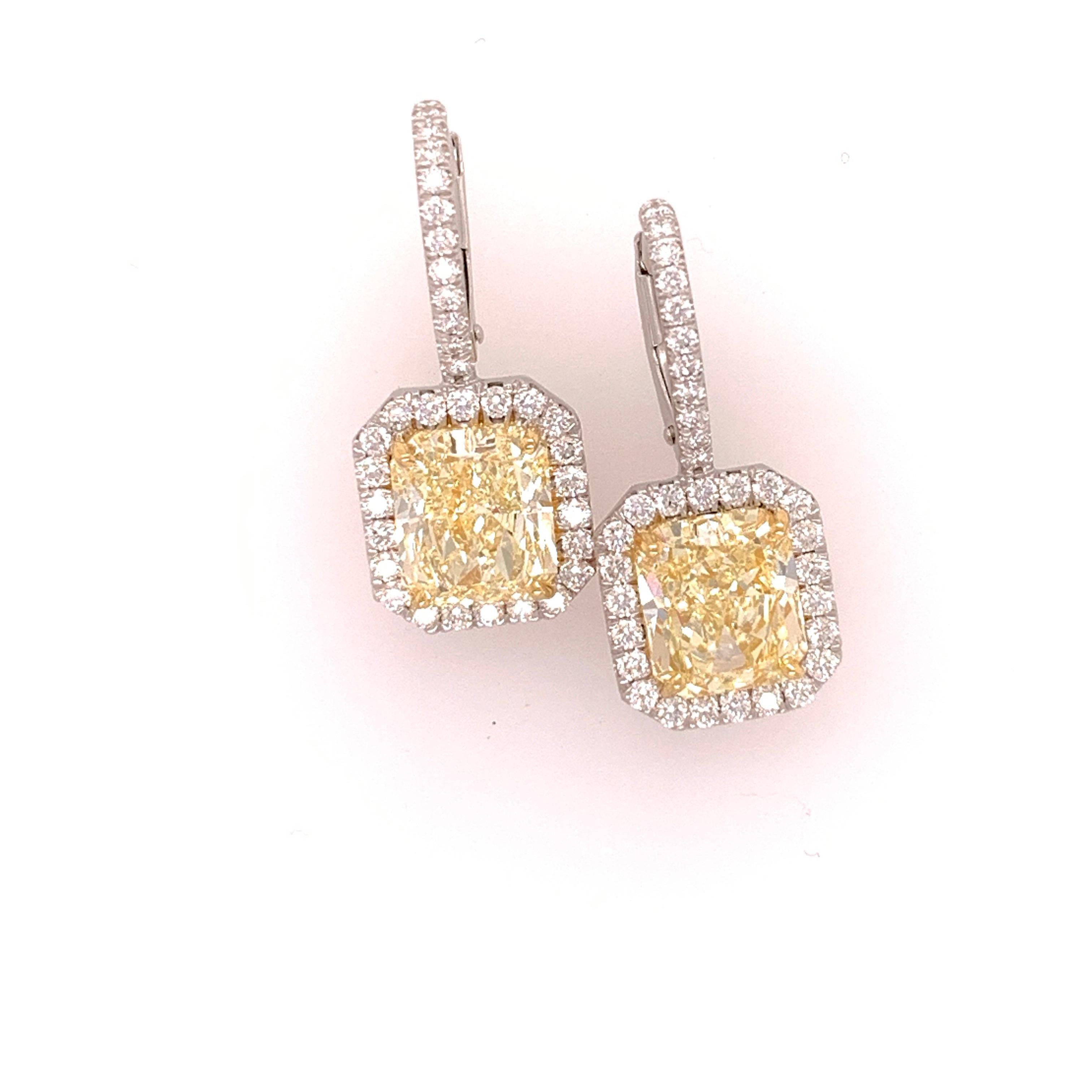 Platinum and 18k fancy light yellow Radiant Cut Diamonds, GIA certified. The first radiant is 2.46 carats, vvs1, no fluorescence. The second radiant is 2.53 carats, vvs2, faint fluorescence. 

Both stones measure over 8.1 x 7 mm

The mountings are