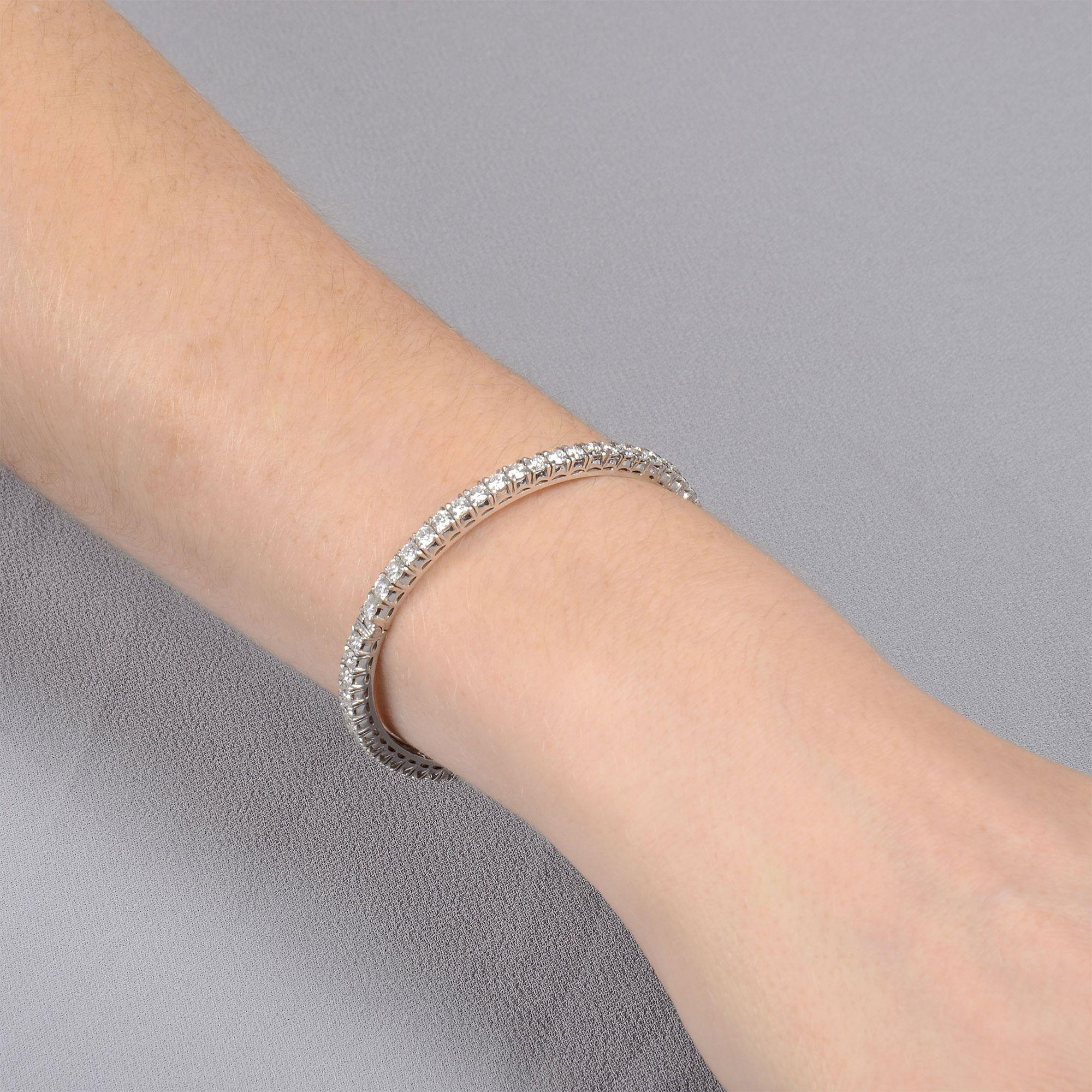 Bracelet articulé en or blanc 18 carats contenant 5,70 CTW de diamants. Ce bracelet bangle à charnière est serti de 57 diamants ronds de taille brillant pour un poids total approximatif de 5,70 carats. Ces diamants ronds et brillants sont calibrés