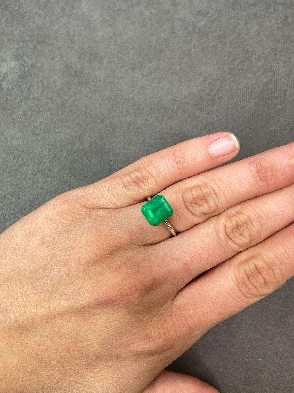 Stone: Emerald
Weight: 5.70-carats
Shape: Emerald Cut
Clarity: Transparent
Luster: Very Good
Color: Yellowish Green
Measurements: 10.45mm x 9.52mm
Geographic Origin: Colombia
Treatment: Natural, Oiling

Comments: Due to their growth conditions in