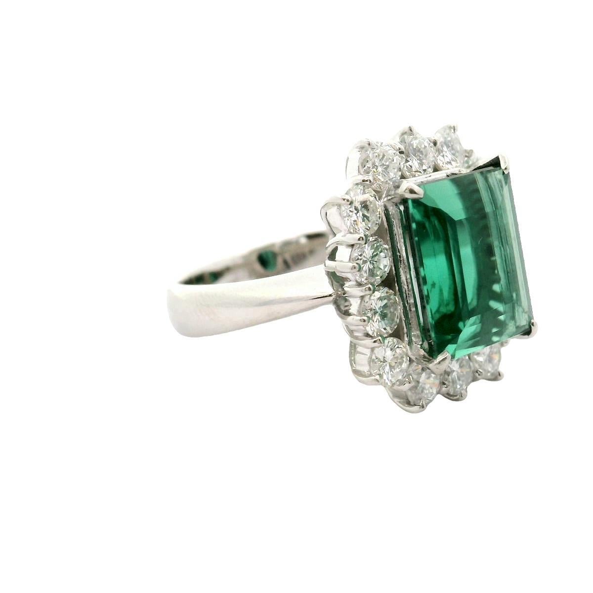 A contemporary fashion ring crafted in platinum, featuring a 5.71-carat step-cut tourmaline with a rich bluish-green color. The vibrant tourmaline is surrounded by 1.76 carats of round brilliant-cut white diamonds, creating striking contrast and a