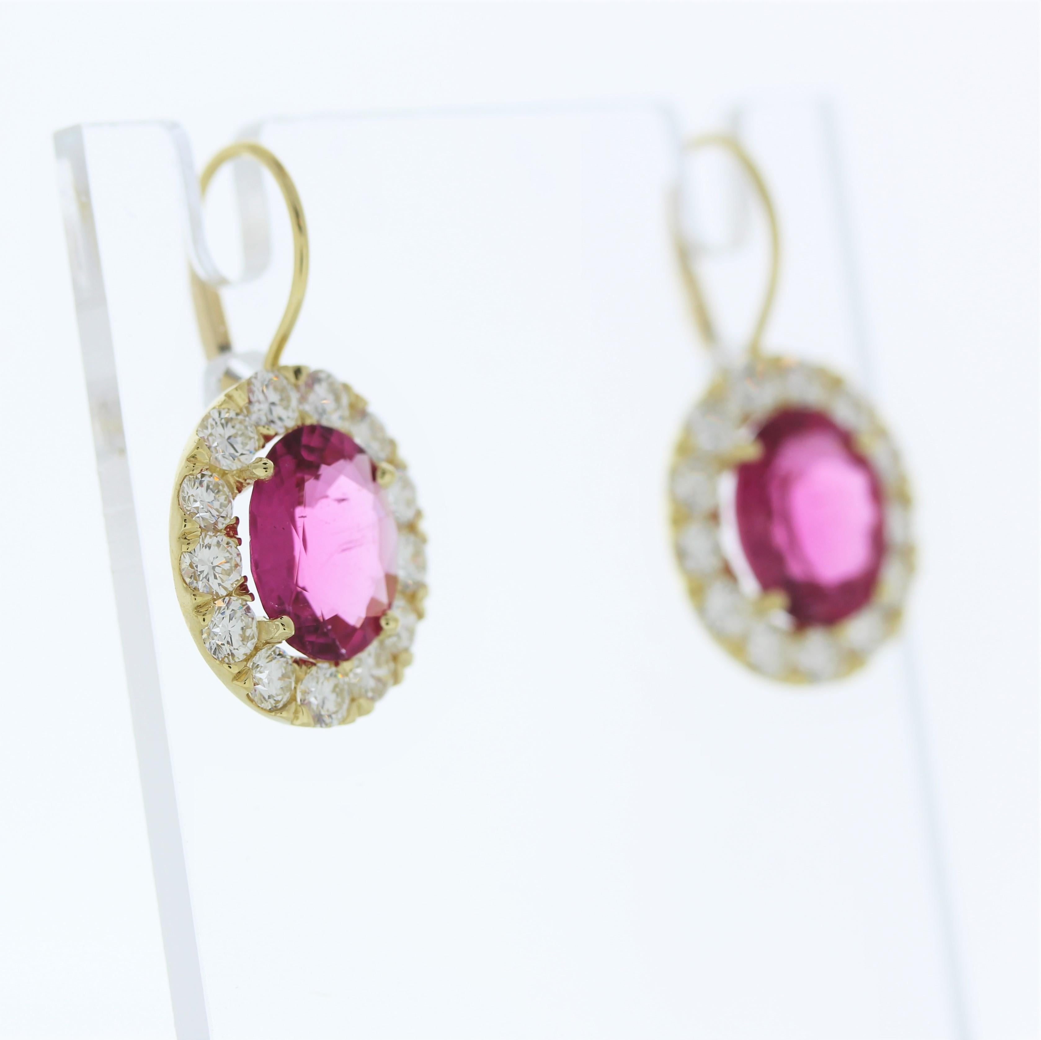 The fashion earrings feature two rubelite gemstones, each weighing 5.72 carats, set in 18 karat yellow gold. They are accented by a total of 26 round-cut diamonds with a combined weight of 2.9 carats in each earring. These earrings are likely to