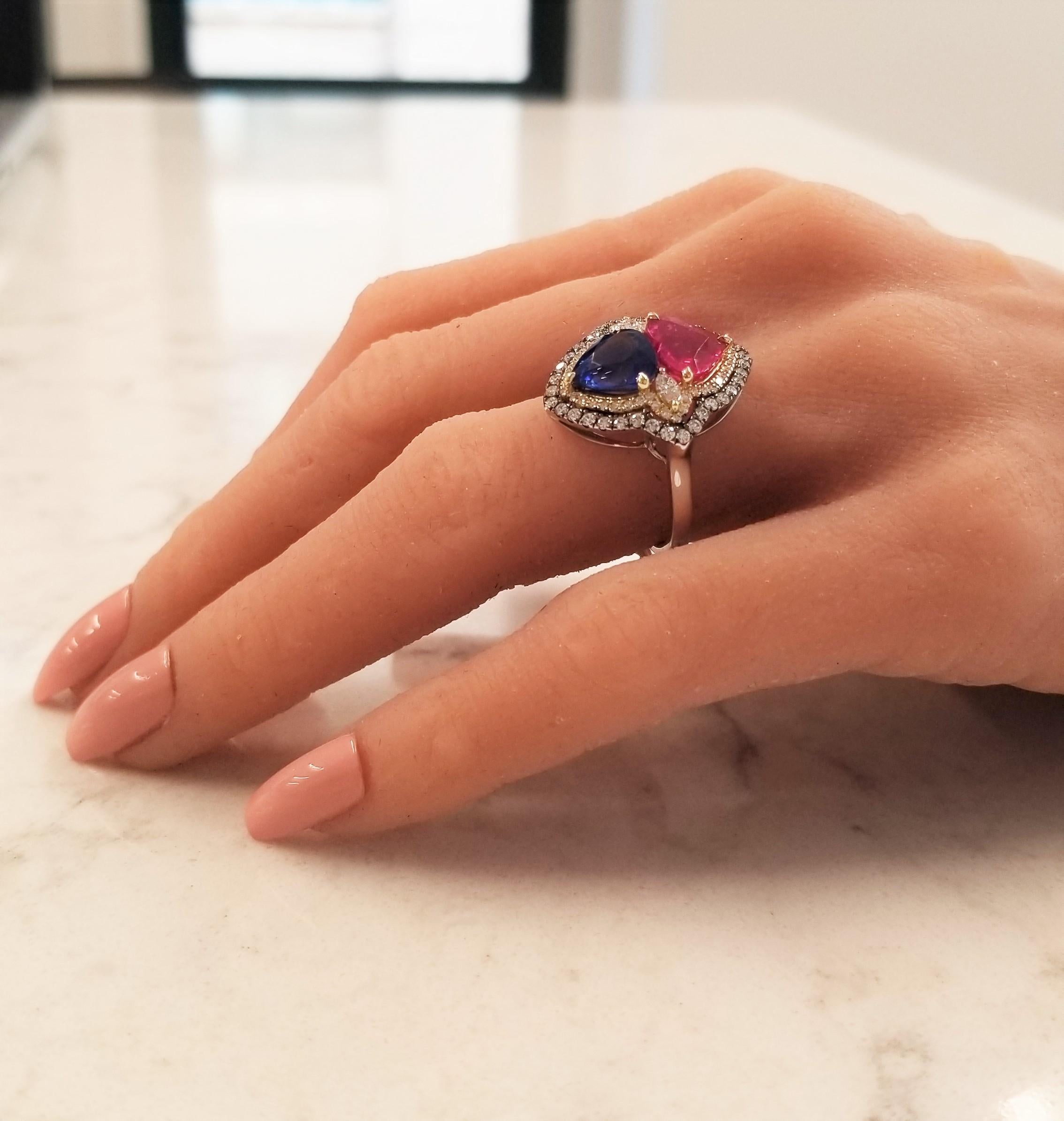 If you want an unparalleled design with top-end precious gems, consider this ring. A 3.02 carat, heart-shaped, blood red ruby is from Thailand. Its color is vibrant; its transparency and luster are excellent. Sharing the attention is a 2.70