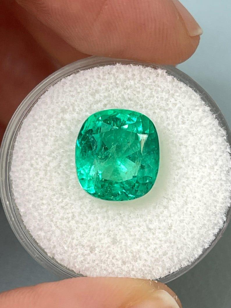 Stone: Emerald
Weight: 5.72-carats
Shape: Cushion Cut
Clarity: Transparent
Luster: Excellent to Very Good
Color: Vivid Bluish Green
Measurements: 11.18mm x 10.20mm x 8.29mm
Geographic Origin: Colombia
Treatment: Natural, Oiling

Comments: Due to