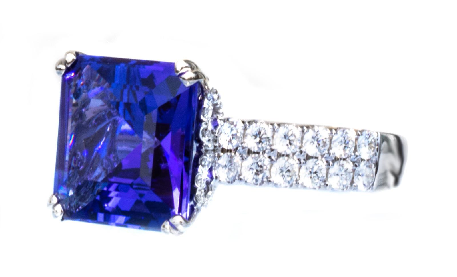 This beautiful ring features a spectacular bluish-purple, natural tanzanite. The Asscher cut showcases gorgeous faceting and is unusual to see with a Tanzanite gemstone.

We put this tanzanite in 18K white gold with 2 rows of large, bright colorless