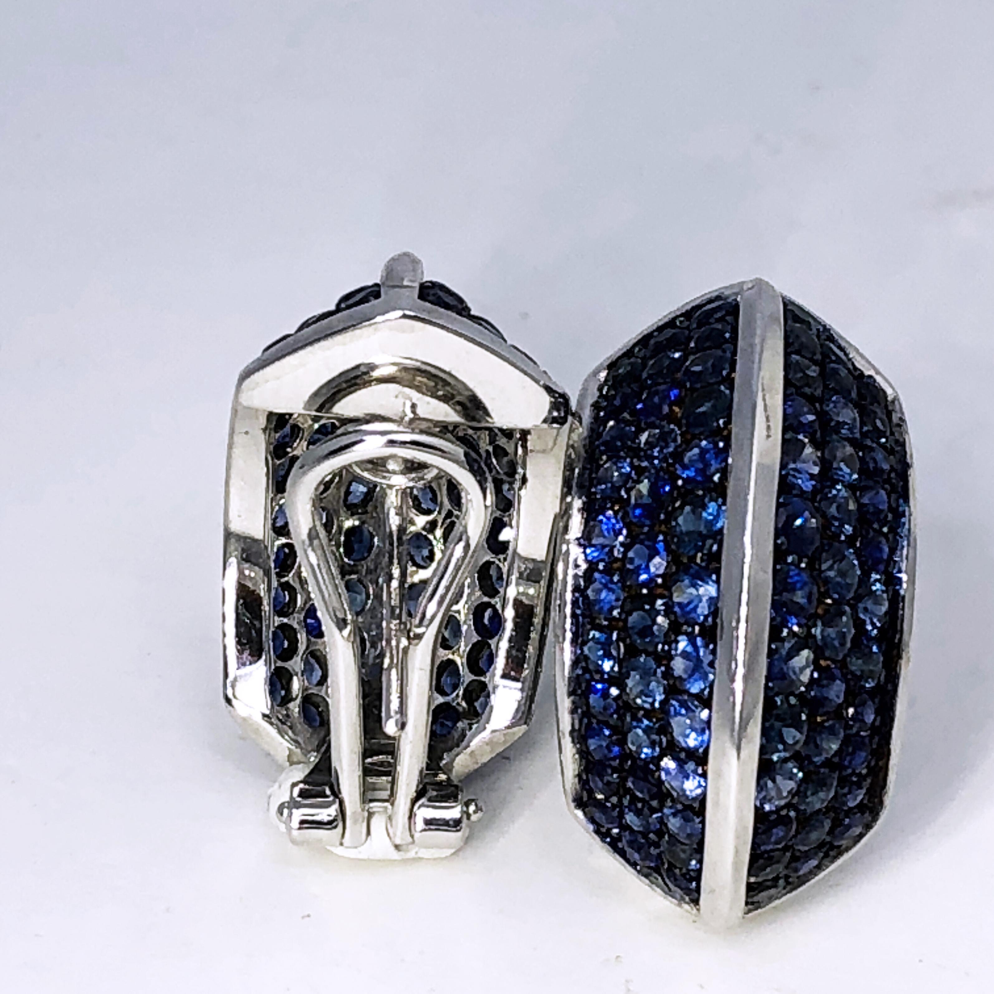 One-of-a-kind Pyramid Shaped Earrings Featuring 5.72 Carat Natural Blue Sapphire in a 13.40g 18K White and Black Gold Setting: the magic of  blue sapphires pavé is enhanced by the mysterious iridescent black gold.
In our fitted dark brown suede