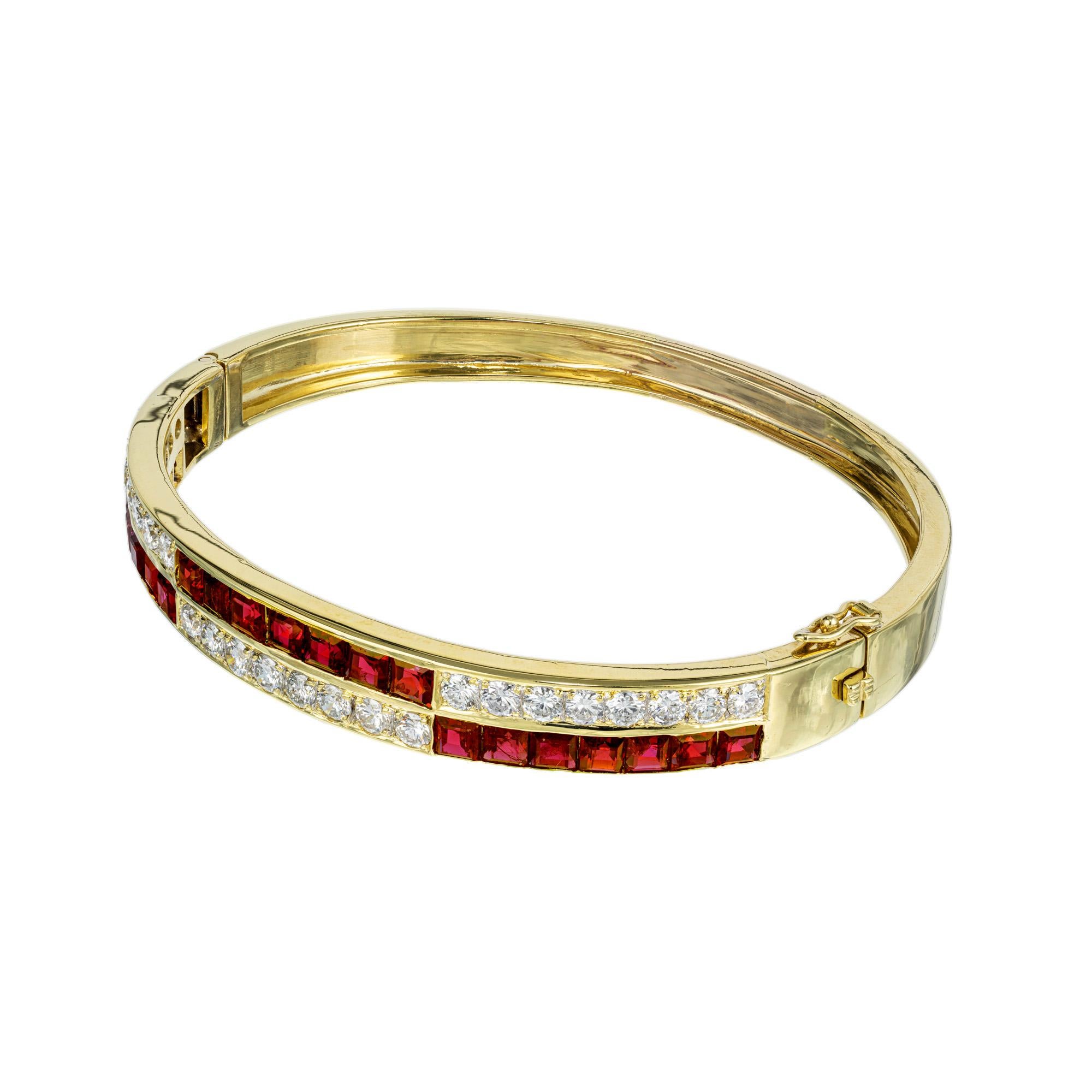 Ruby and diamond bangle bracelet. Alternating rows of 21 square shape rubies and 24 round cut diamonds set in a 18k yellow gold hinged bangle bracelet. The rubies are a rich medium red with bright white full cut diamonds. The oval shaped bracelet