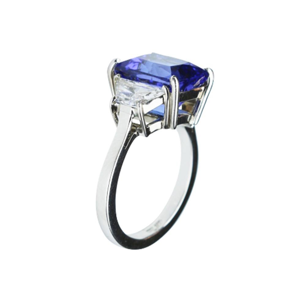 Elegant & finely detailed Solitaire Engagement  Ring, center set with a securely nestled 5.73 Carat Cushion-cut Vivid Blue Tanzanite, clarity: internally flawless (IF); dimensions: 10.2mm x 9.0mm, either side set with approx. Brilliant full cut