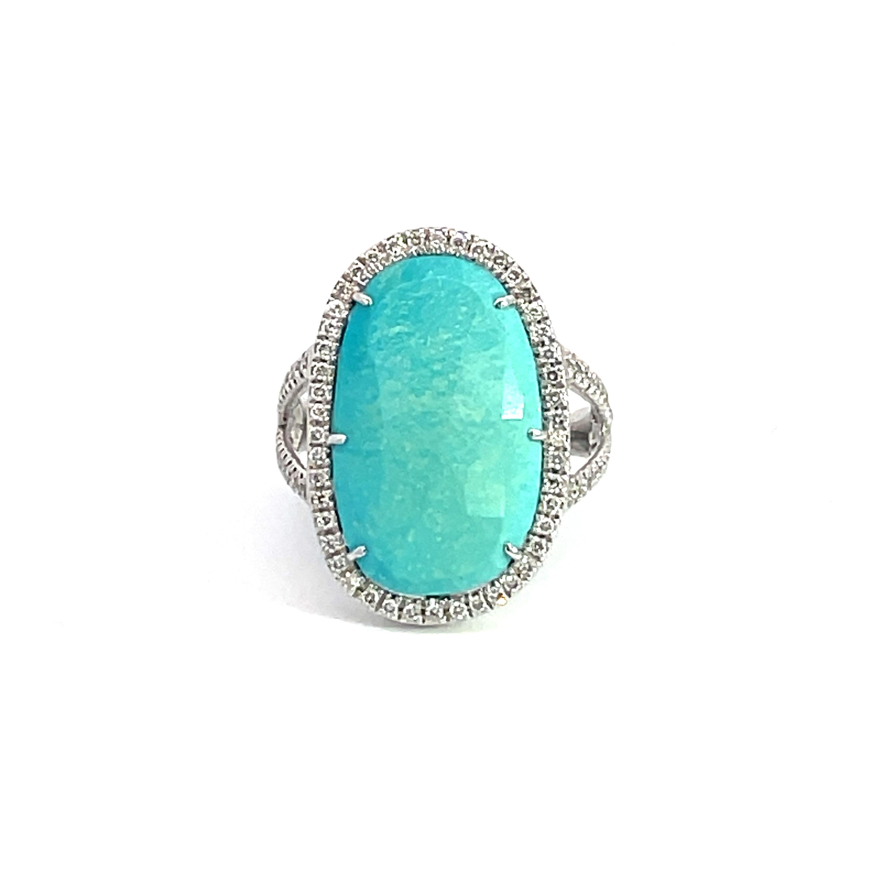 Dieser atemberaubende Cocktailring zeigt einen wunderschönen ovalen Türkis von 5,74 Karat mit einem Diamant-Halo, auf einem doppelten Diamantschaft. Dieser Ring ist in 18K Weißgold gefasst. 
Gesamtgewicht der Diamanten = 0,31 Karat. Die Ringgröße