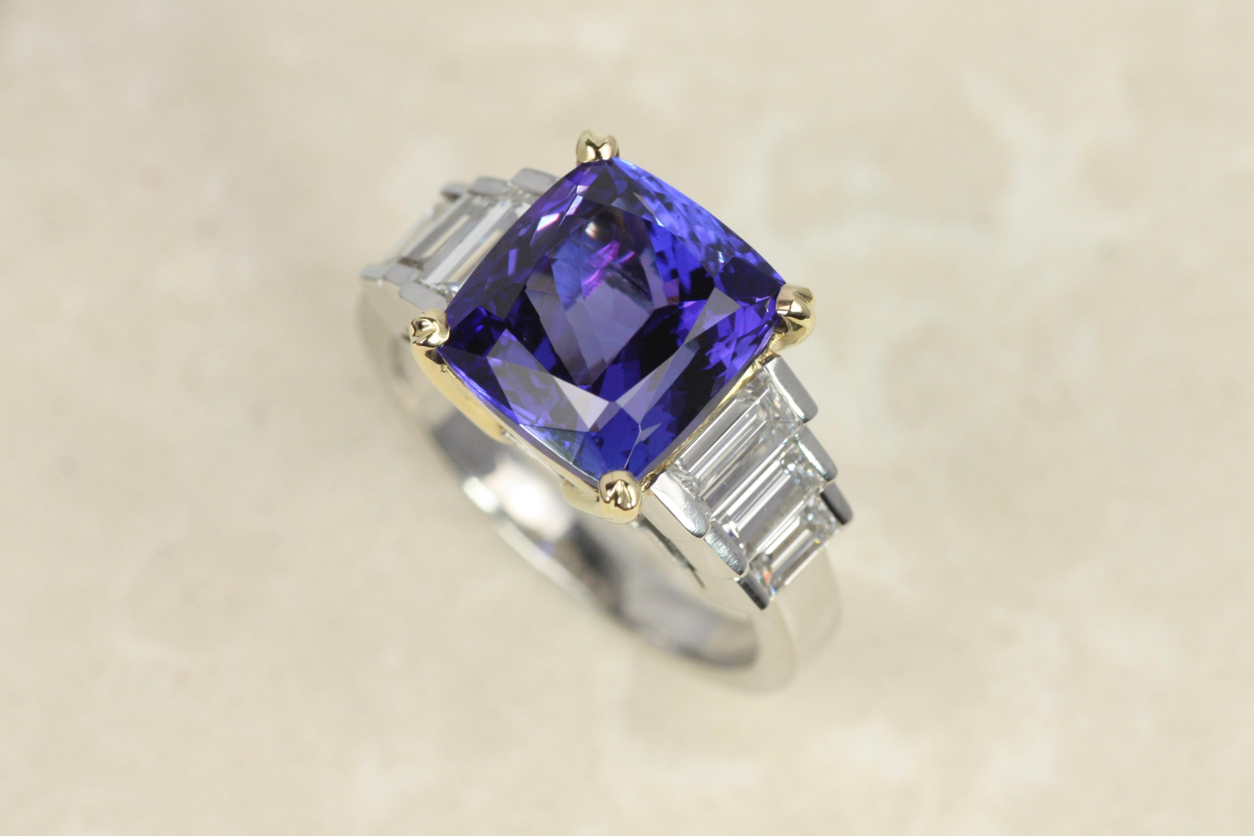 Luminous and dramatic, this cocktail ring showcases a breathtaking 5.74ct tanzanite with deep violet and electric blue flashes. Six baguette-cut diamonds elegantly frame the center stone and are set in polished platinum. The 18K yellow gold head