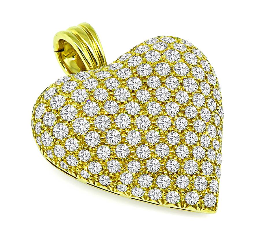 This is an elegant 18k yellow gold heart pendant/pin. The pendant is set with sparkling round cut diamonds that weigh approximately 5.75ct. The color of the diamonds is F with VS clarity. The pendant measures 41mm by 32mm and weighs 21.5 grams. The