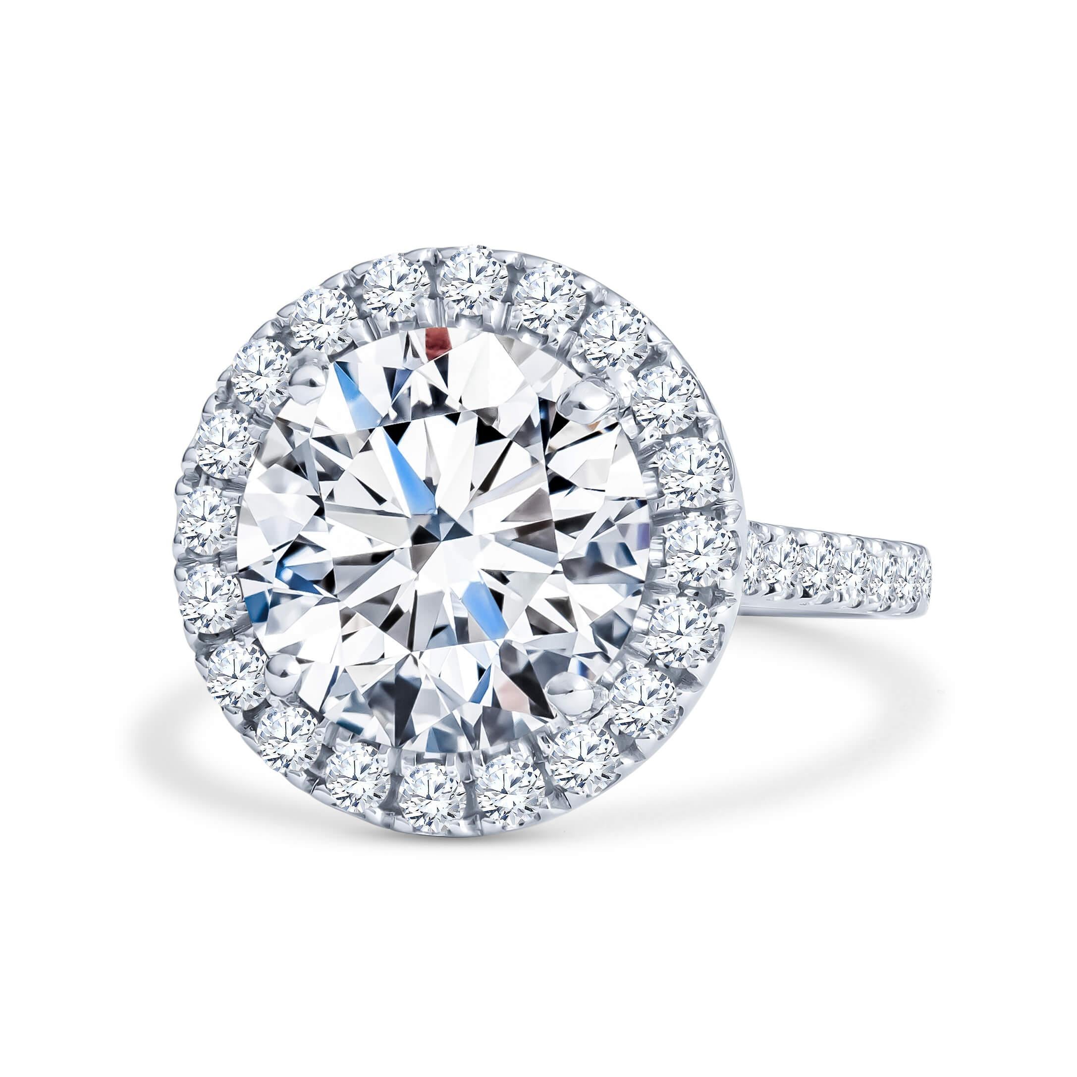 This engagement ring has a 5.75ct round brilliant cut diamond set in a 14kt white gold round halo ring and a 1.50ct total weight in round diamonds going halfway down. It has a 2.2mm shank and is a size 6 but can be resized upon request. The center