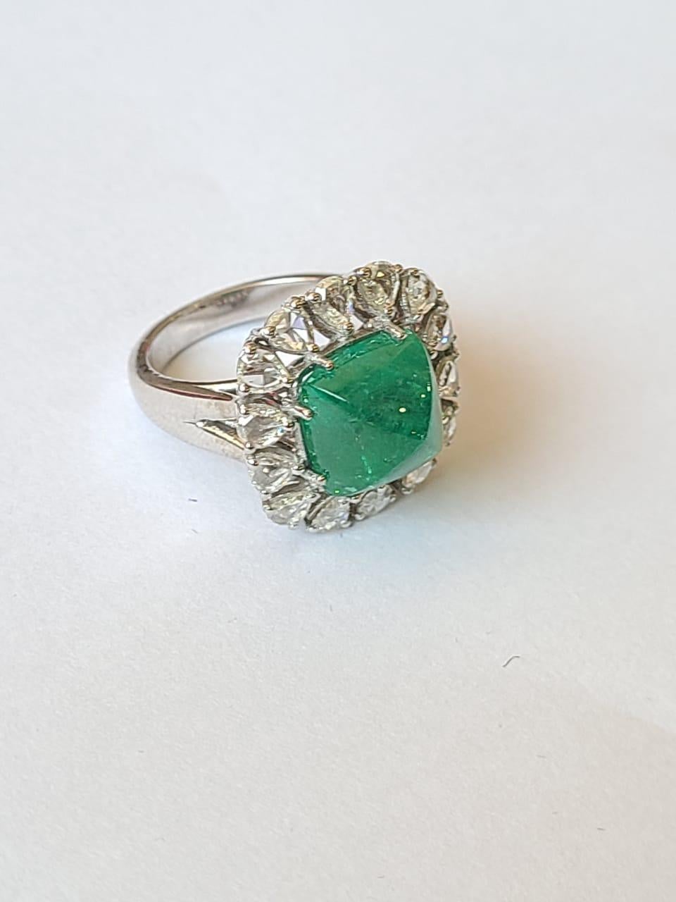 A very dainty and beautiful Emerald Cocktail/ Engagement Ring set in 18K Gold & Diamonds. The weight of the Emerald sugarloaf cabochon is 5.76 carats. The Emerald is of Zambian origin and is completely natural, without any treatment. The weight of