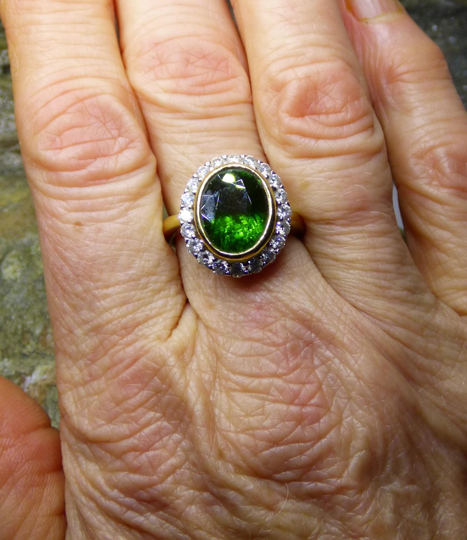 Contemporary 5.77ct Oval Green Tourmaline and Diamond Cluster Ring in 18K Gold. For Sale