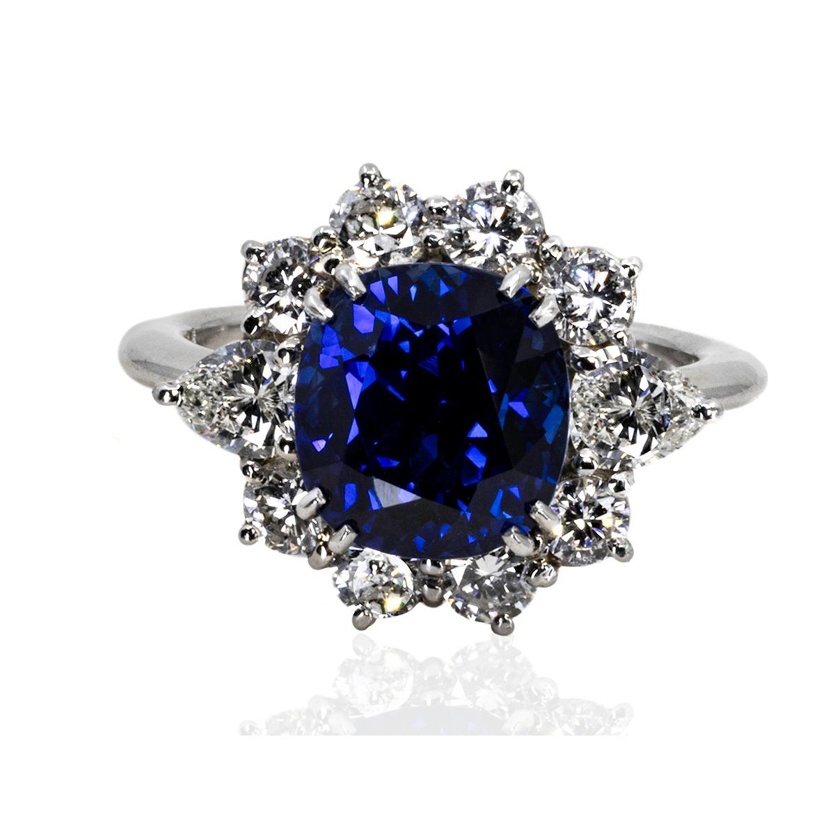 Anello in platino con zaffiro blu reale del peso di 5,78 carati e accompagnato da un certificato degli American Gem Labs. Inoltre ci sono 8 diamanti tondi taglio brillante e 2 diamanti taglio pera per un peso di 1,31 carati. 
Peso totale 8,58 g