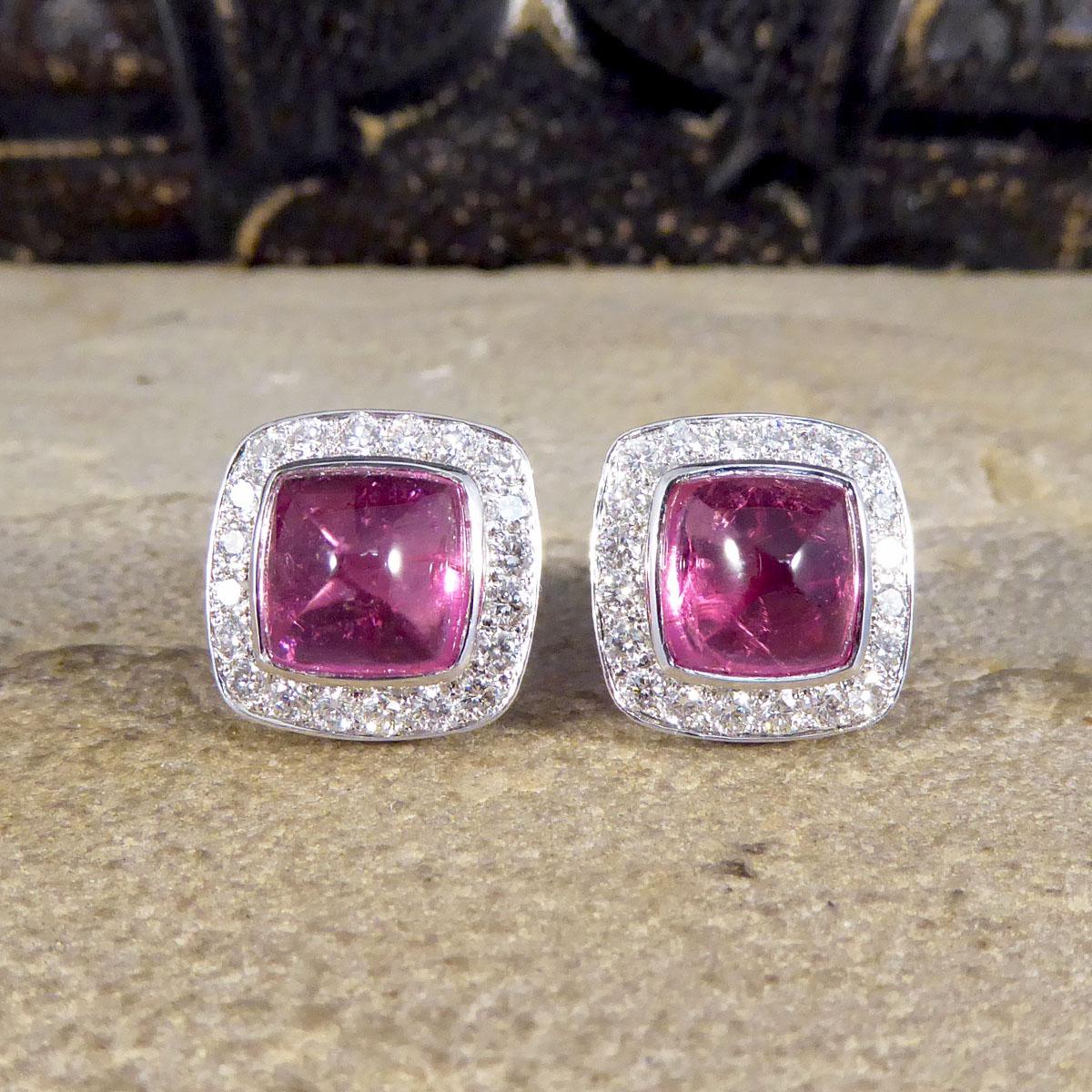 Such a beautiful pair of contemporary earrings made with quality stones and craftsmanship. Each stud features a Sugarloaf cut Pink Tourmaline in the centre weighing 2.89ct each in a rub over setting with a halo border of brilliant cut Diamonds in a