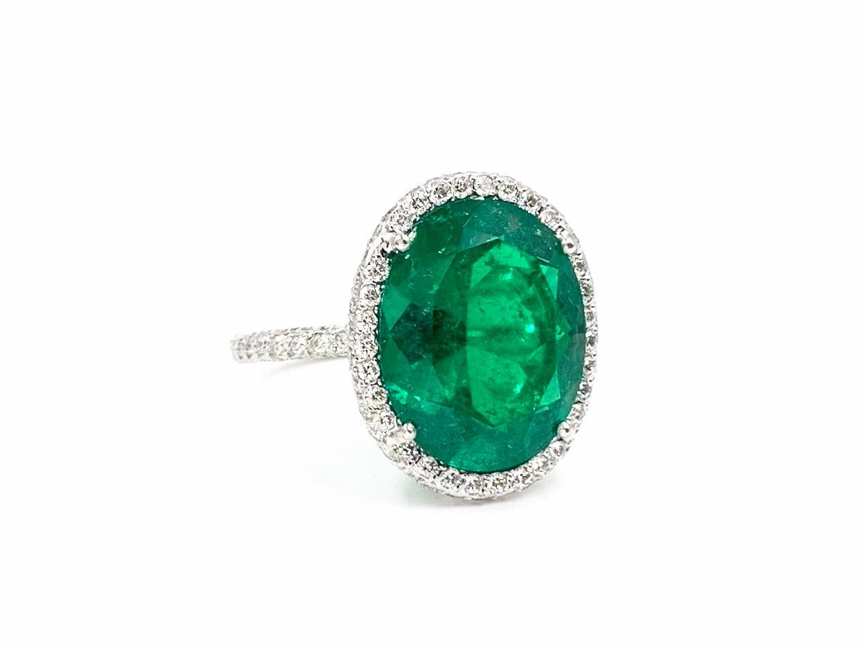 An exquisite 5.79 carat oval shape genuine emerald is perfectly framed by a thin diamond pavé halo in this gorgeous platinum cocktail ring. Expertly crafted by Italian designer, Giovane with a diamond total weight of .94 carats. Diamond quality is