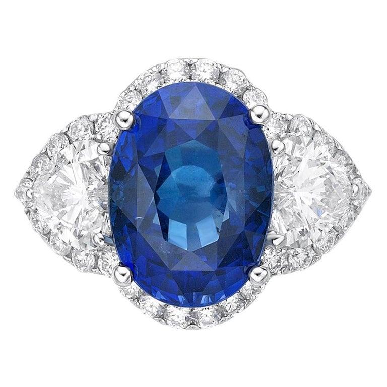 This breathtaking ring features in its very center a 5.79 unheated vivid royal blue sapphire, framed by two heart shape diamonds with a combined weight of 1.01 ct and surrounded by a halo of diamonds. This sapphire sets the standard for how a