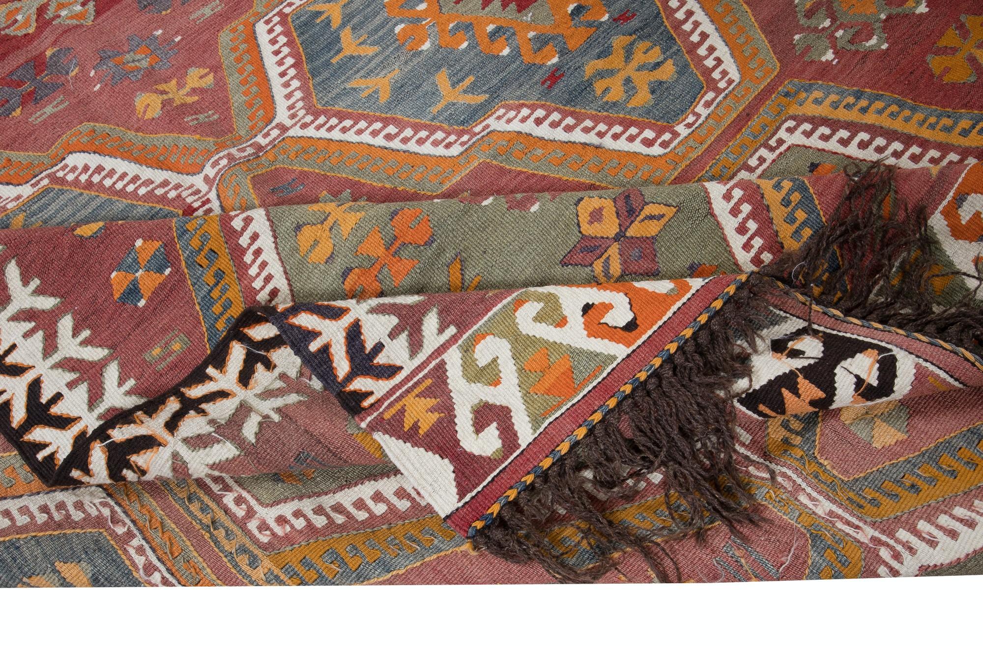 Embark on a journey through Turkish tradition with this exquisite vintage handwoven Turkish wool kilim rug, a testament to the enduring craftsmanship of Anatolian artisans. Woven with meticulous care and attention to detail, this kilim rug