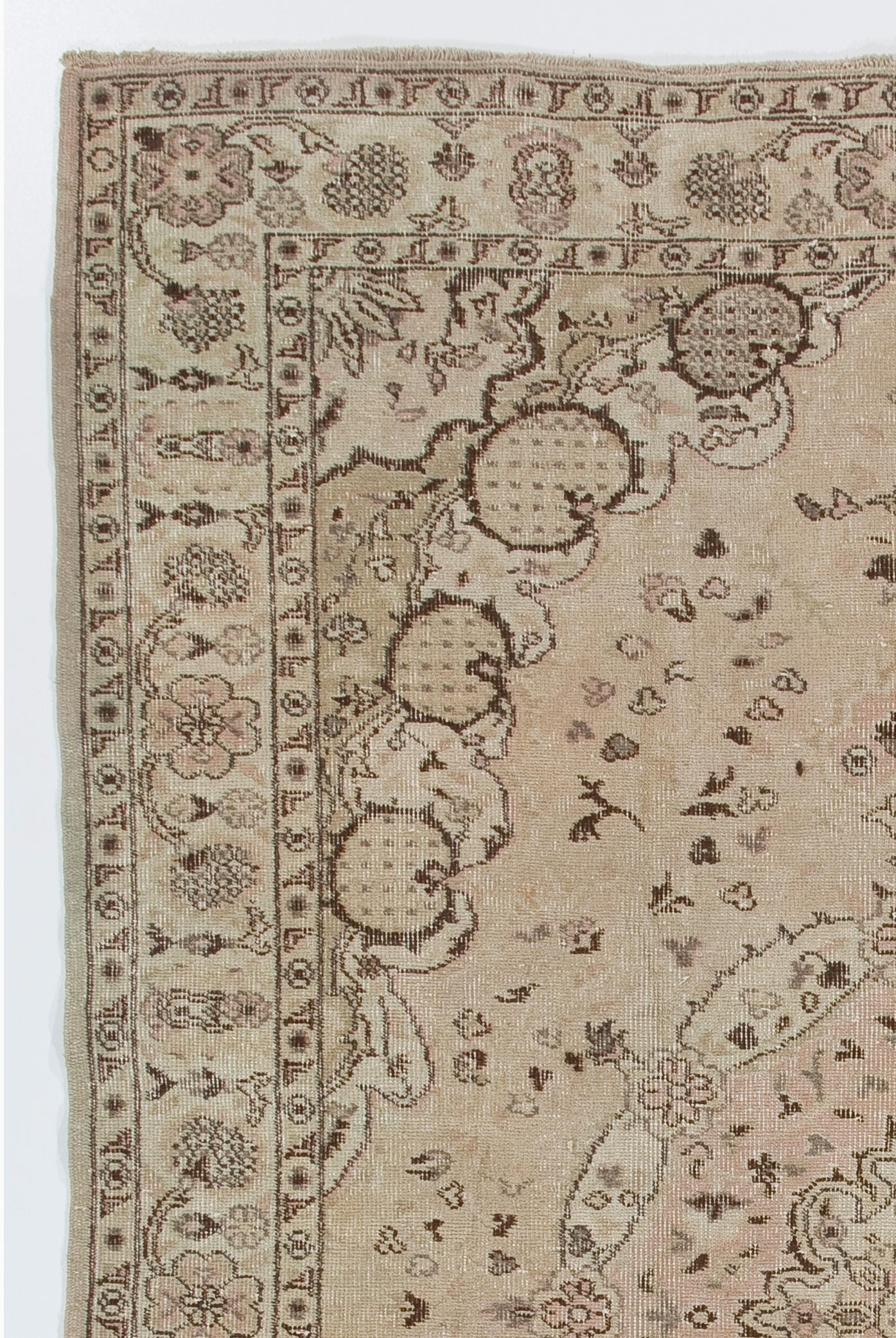 This one-of-a-kind vintage Turkish area rug is finely hand-knotted with low wool pile on cotton foundation. It features an elegant medallion against a field decorated with floating delicate petals framed by corner pieces with pomegranate-like motifs