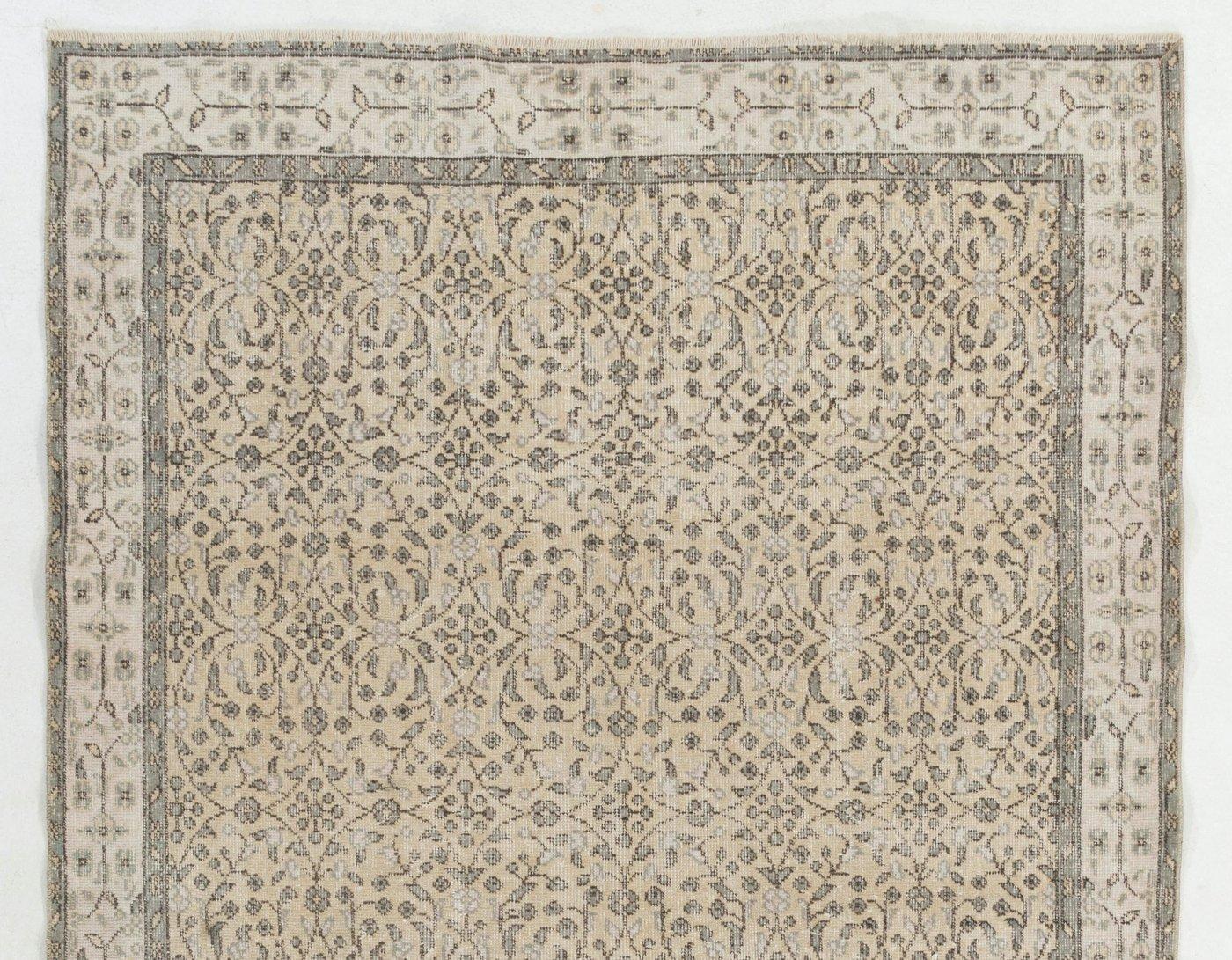 A finely hand-knotted vintage Turkish Oushak area rug from the 1960s featuring a delicate all-over design of scrolling floral and leafy vines in greenish gray and ivory that form circular lattices against a lovely pale yellow background. The ivory