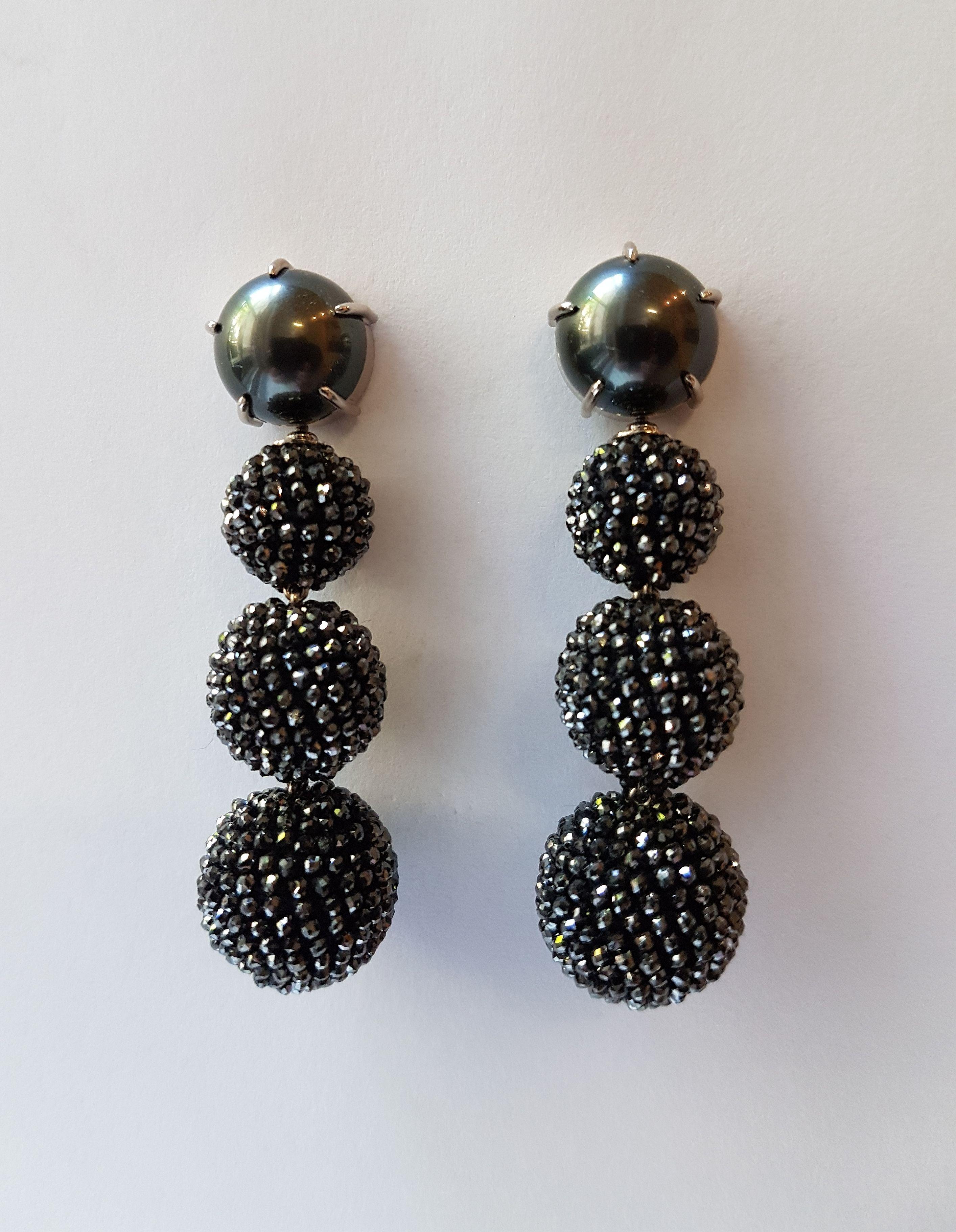 Spactacular detachable earrings made of 750/0 white gold, 2 black Tahiti pearls (13 mm each) and 3 balls (12, 14 and 16 mm) consisting of 58 carats black diamonds. 
These extravagant and unique earrings designed by Christine Köppel earrings will add