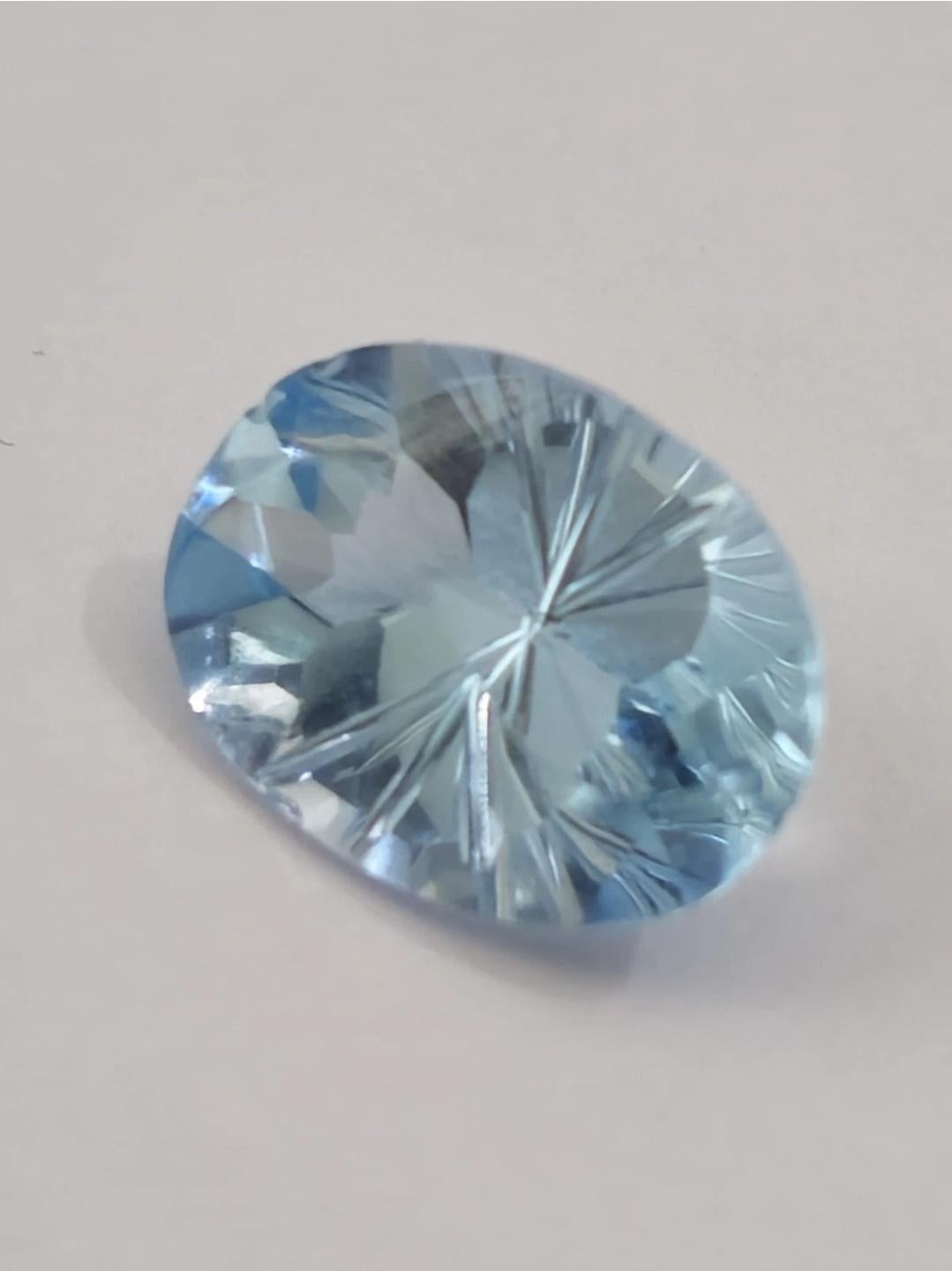 Immerse yourself in the captivating beauty of this 5.8 ct natural oval sky blue topaz, a gemstone that boasts a mesmerizing fantasy cut. The vibrant blue hue and oval shape make it an ideal choice for a variety of jewelry designs, from classic to