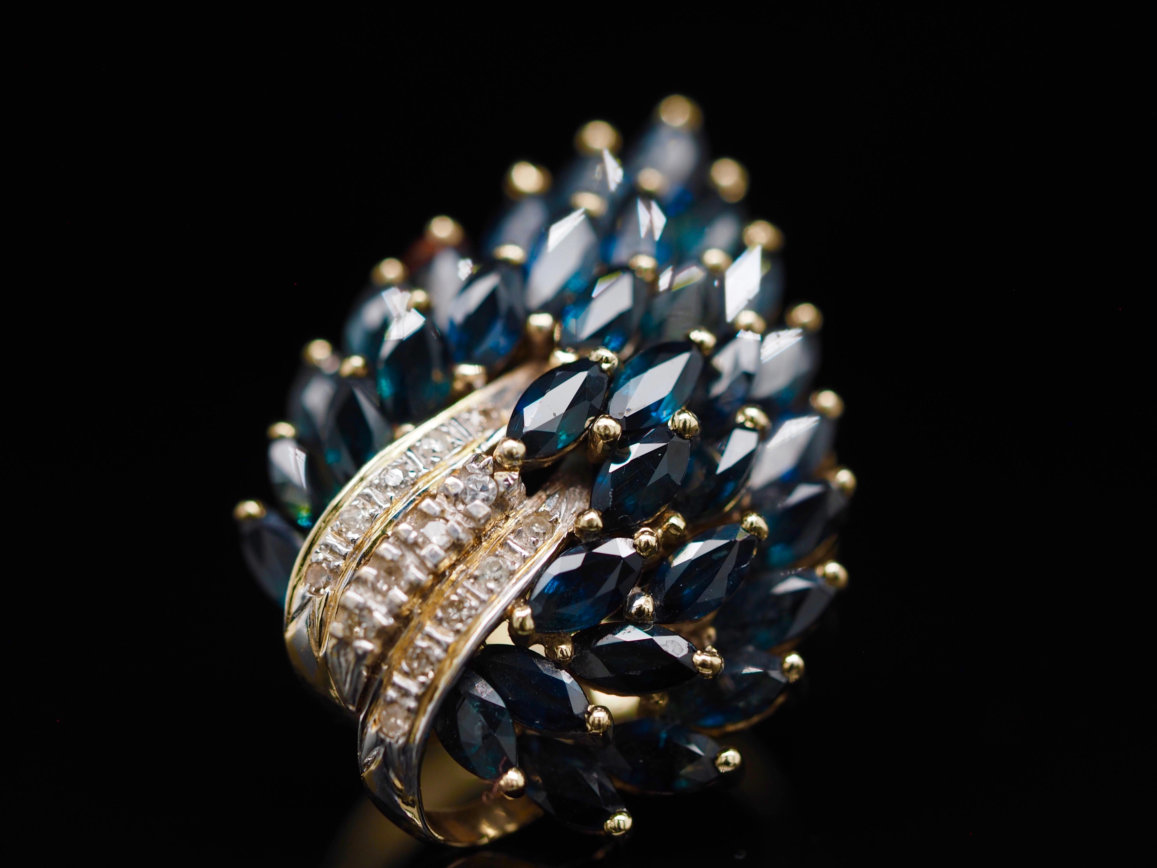 Dieser großartige Ring ist übervoll mit natürlichen blauen marquiseförmigen Saphiren! Er ist das perfekte Statement. Die Art und Weise, wie die Saphire gefasst sind, ergibt ein pfauenartiges Design. Der Hauch von Diamanten ist der perfekte