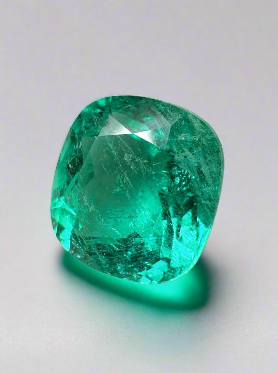 Stone: Emerald
Weight: 5.80-carats
Shape: Cushion Cut
Clarity: Transparent
Luster: Excellent-Very Good
Color: Bluish Green
Measurements: 11.66mm x 11.01mm x 7.20mm
Geographic Origin: Colombia
Treatment: Natural, Moderate Oil

Comments: Due to their