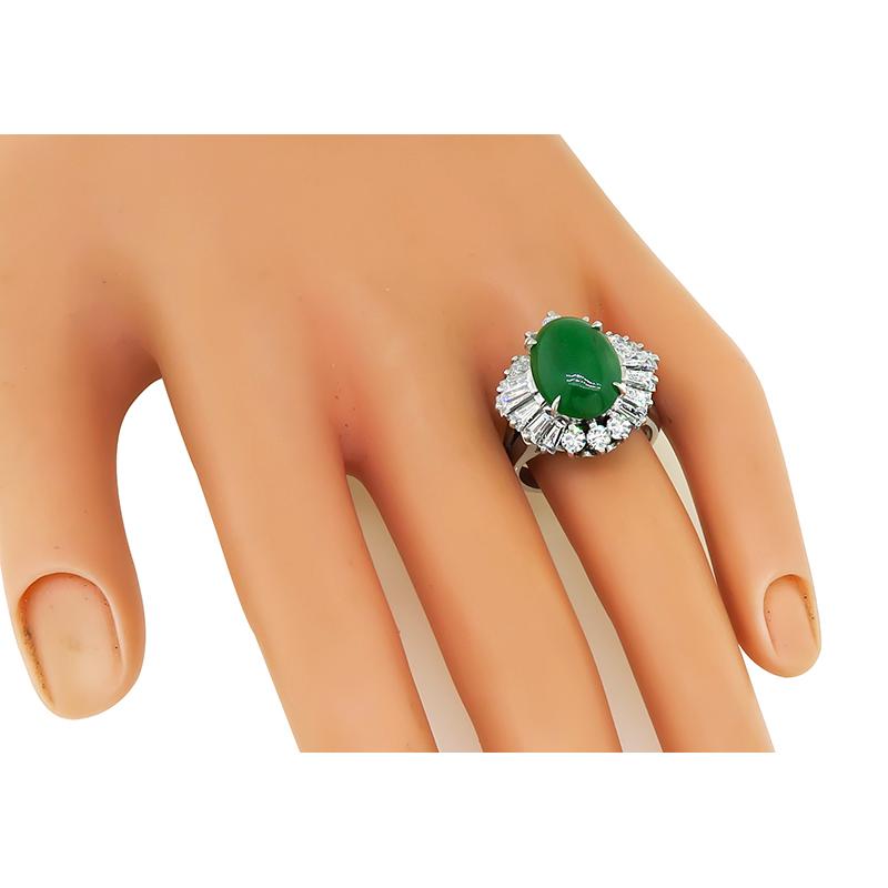 This is an amazing platinum cocktail ring. The ring is centered with a lovely cabochon jade that weighs approximately 5.80ct. The jade is accentuated by sparkling baguette and round cut diamonds that weigh approximately 2.43ct. The color of these