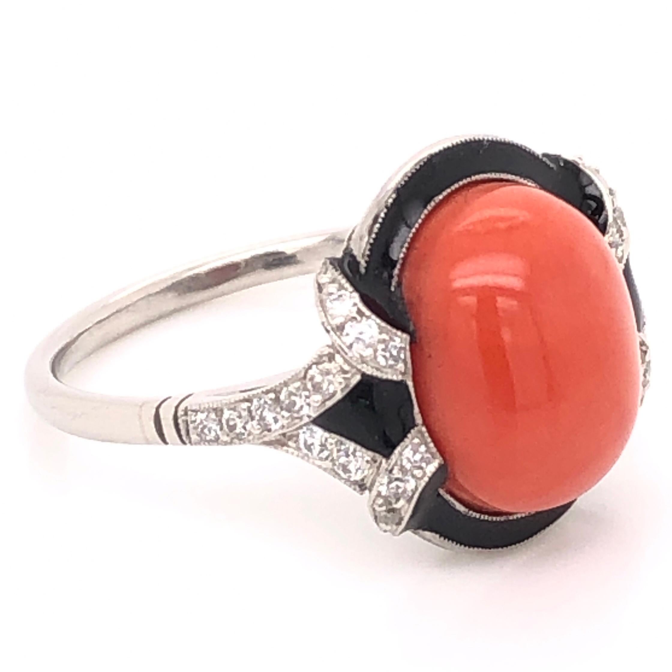 Simply Beautiful and Finely Detailed Platinum Cocktail Ring center securely set with a 5.81 Carat Oval Cabochon Coral accented by Black Enamel and Diamonds, approx. 0.32 total carat weight. The head is 15.5mm North-South x 16.5mm East-West. Hand