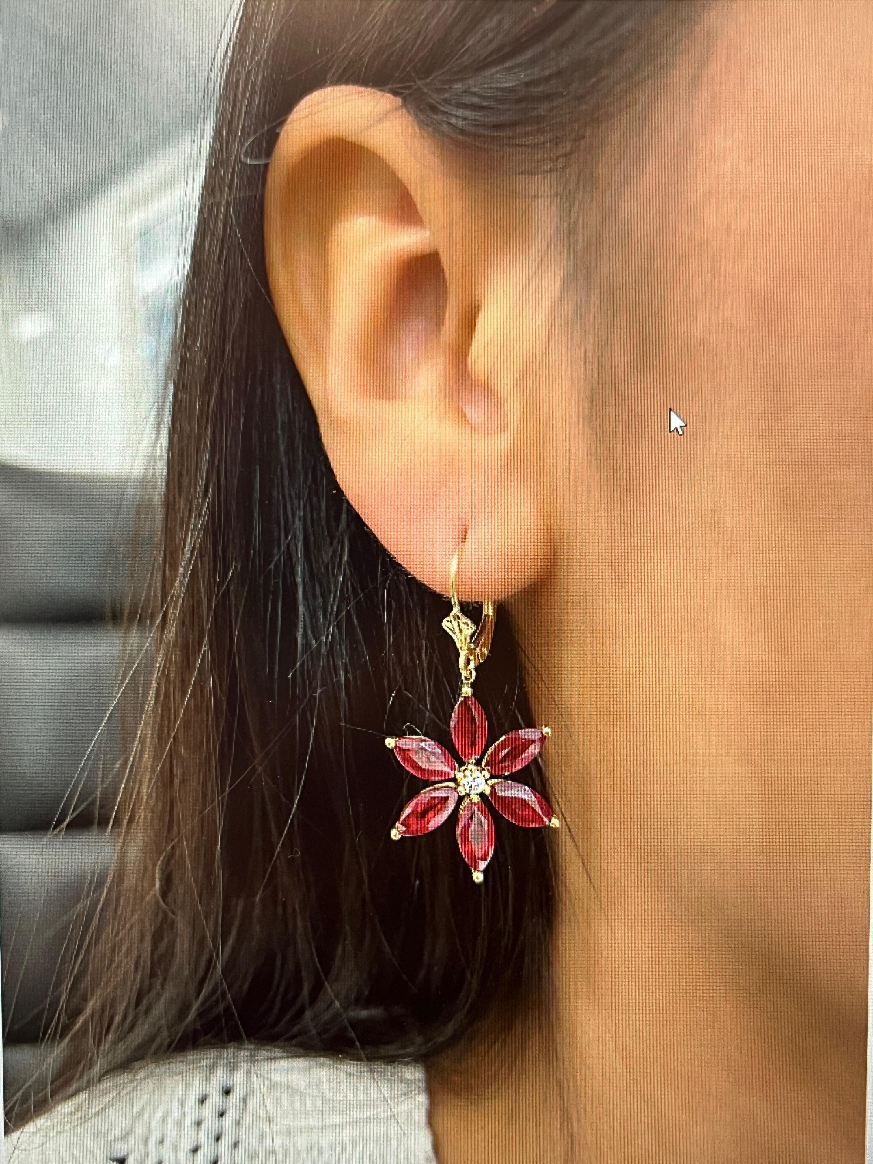 These gorgeous 5.81 ct natural ruby, and diamond flower shaped earrings are set in 18k yellow gold. The diamonds are F/G in color and VS2/SI1 in clarity. A great addition to any wardrobe. 