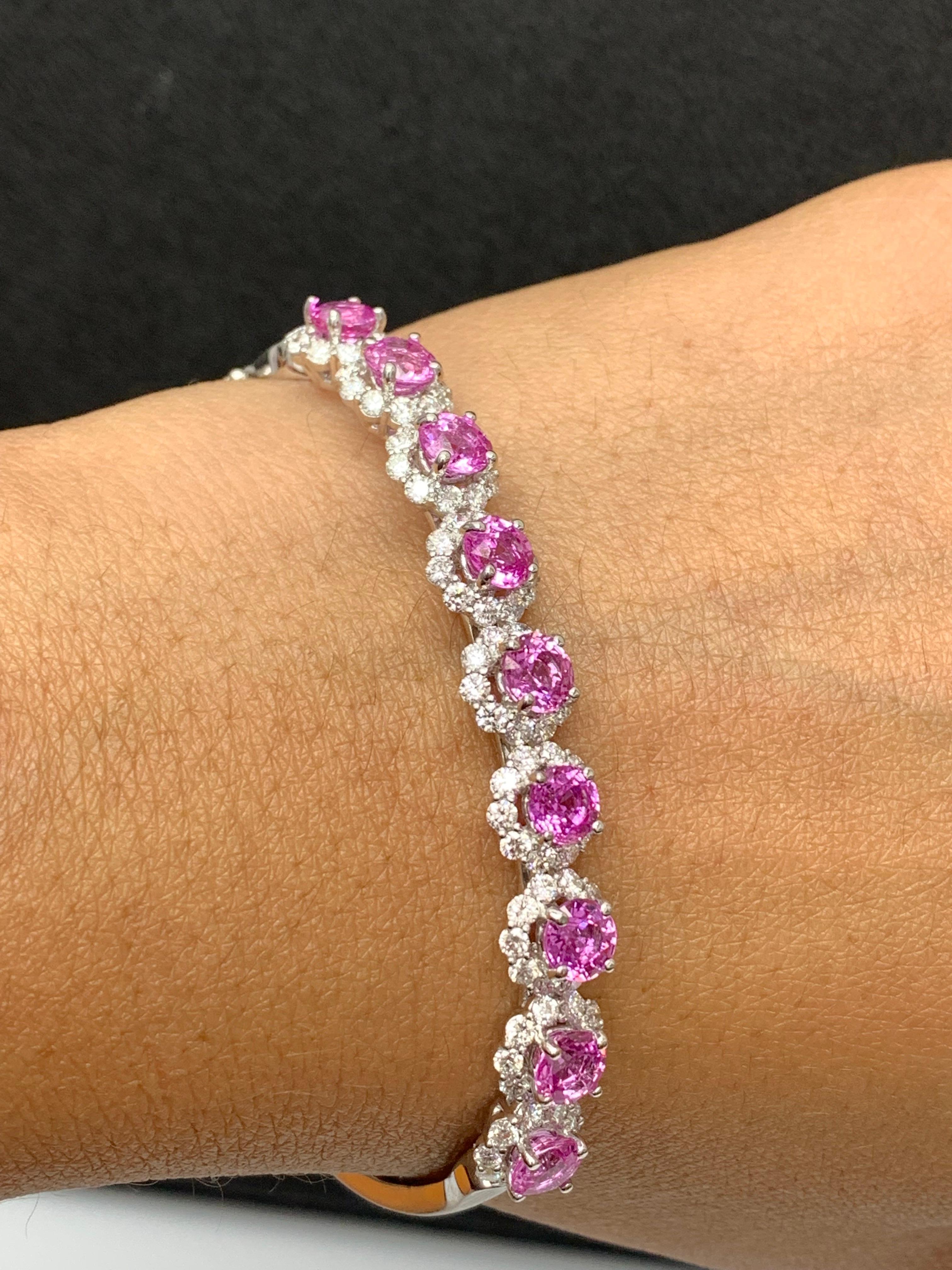 Sparkle in the spotlight with this brilliant cut pink sapphire and diamond bangle bracelet. Features 9 brilliant-cut round pink sapphires weighing 5.82 carat and surrounding the pink sapphires are 90 diamonds weighing 2.45 carat elegantly set in a