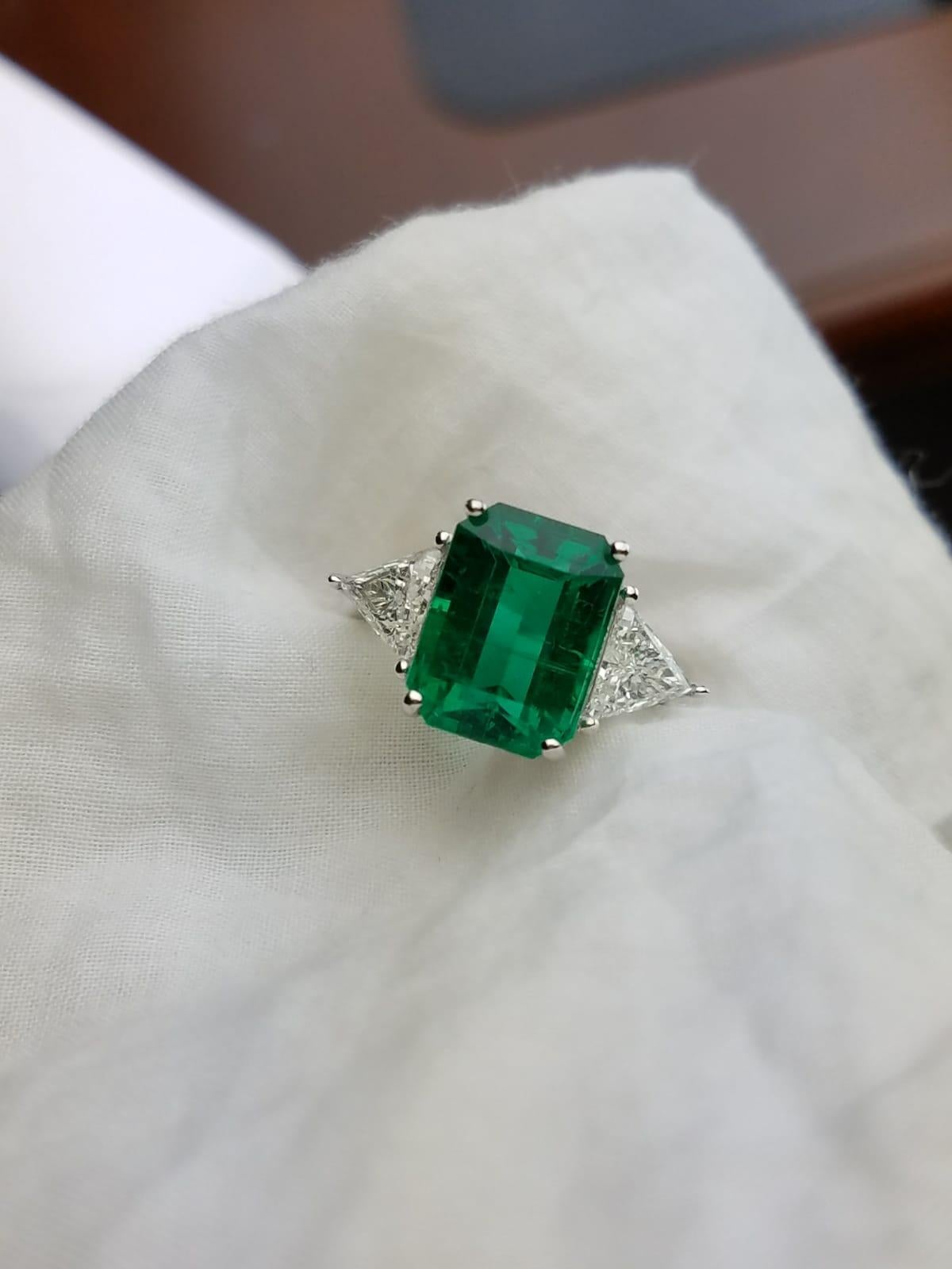 A classic three stone ring, with a 5.82 carat high quality and great colour emerald cut Zambian Emerald centre stone and 2 trapeze 0.83 carat side stone Diamonds. 

Stone Details: 
Stone: Emerald
Carat Weight: 5.82 Carats

Diamond Details: 
Total