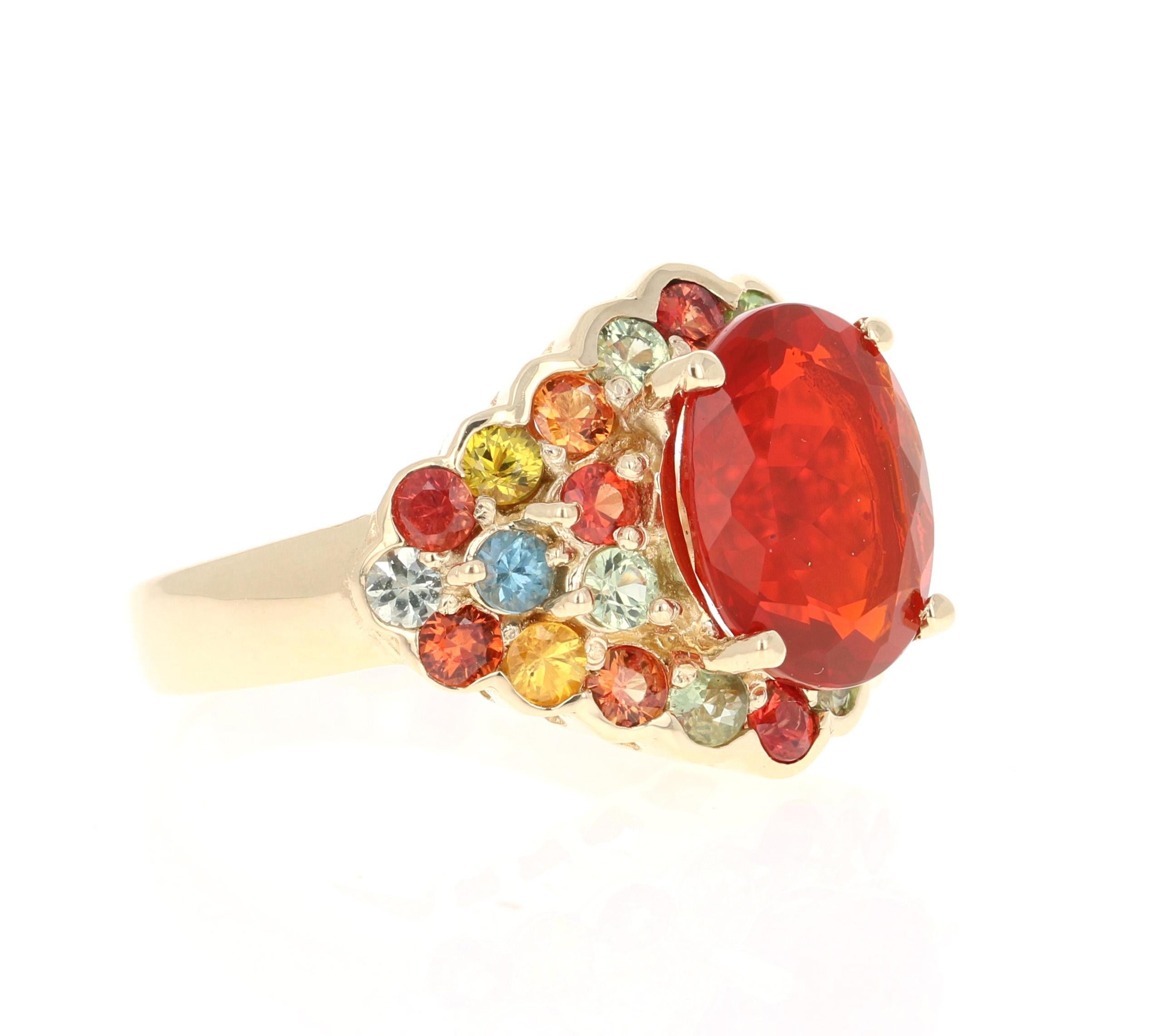 This ring has a 3.17 Carat Oval Cut Fire Opal as its center stone and is elegantly surrounded by 26 Round Cut Multi-Colored Sapphires that weigh 2.65 Carats. The measurements of the Fire Opal are 11 mm x 13 mm. 
The total carat weight of this ring