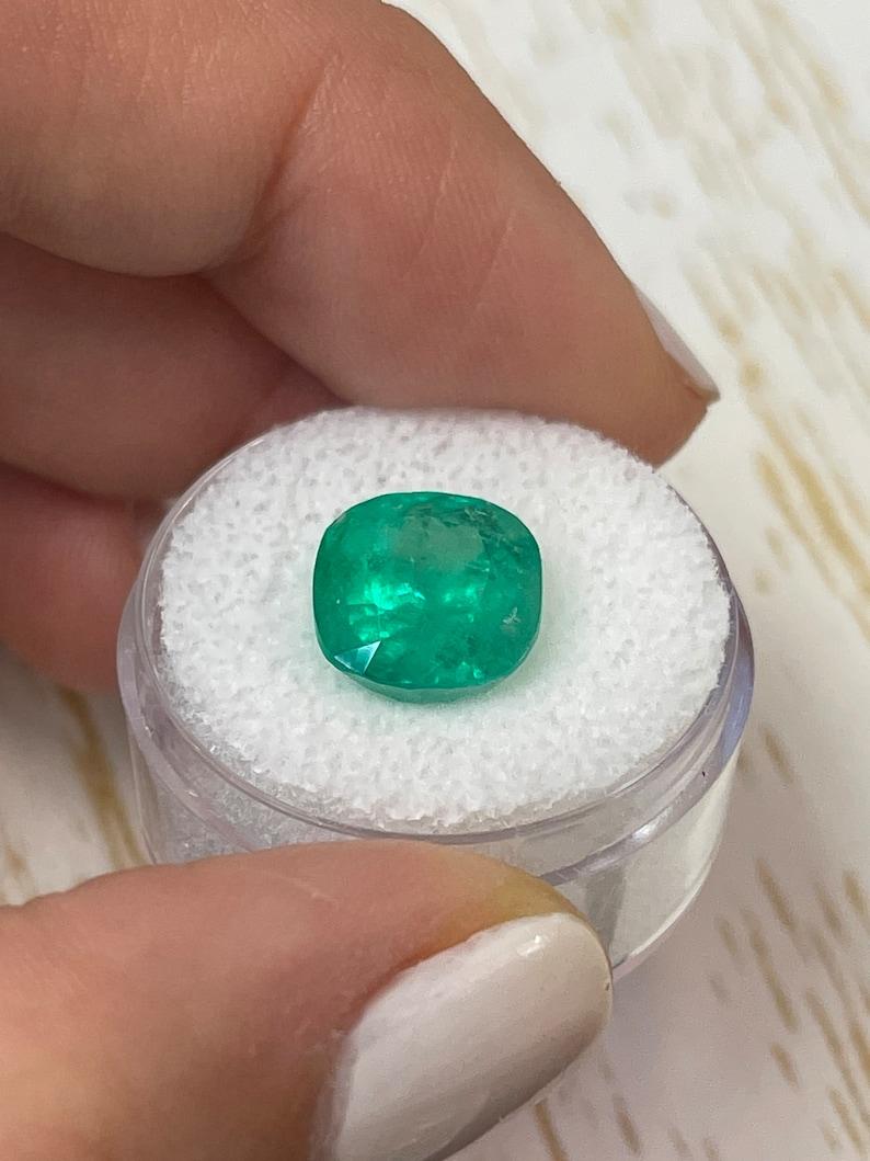 Stone: Emerald
Weight: 5.83-carats
Shape: Cushion Cut
Clarity: Semi-Transparent
Luster: Very Good
Color: Medium Intense Green
Measurements: 10.89mm x 10.63mm x 8.45mm
Geographic Origin: Colombia
Treatment: Natural, Oiling

Comments: Due to their