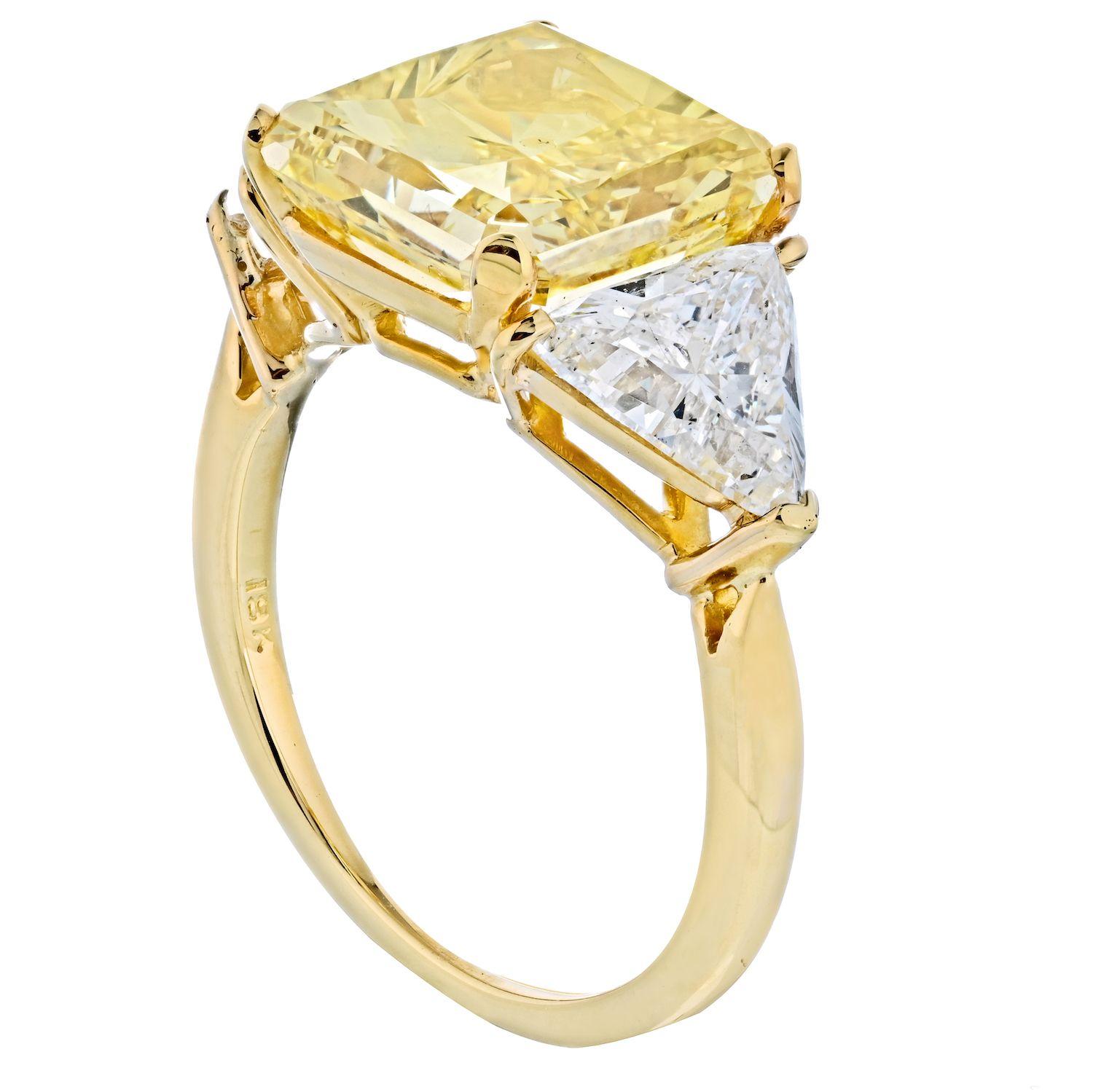 If you prefer your jewelry being made in yellow gold, then this is a ring for you! Three stone diamond engagement ring crafted in 18k yellow gold, mounted with 5.83 Carat fancy vivid yellow radiant cut diamond flanked by white brilliant cut