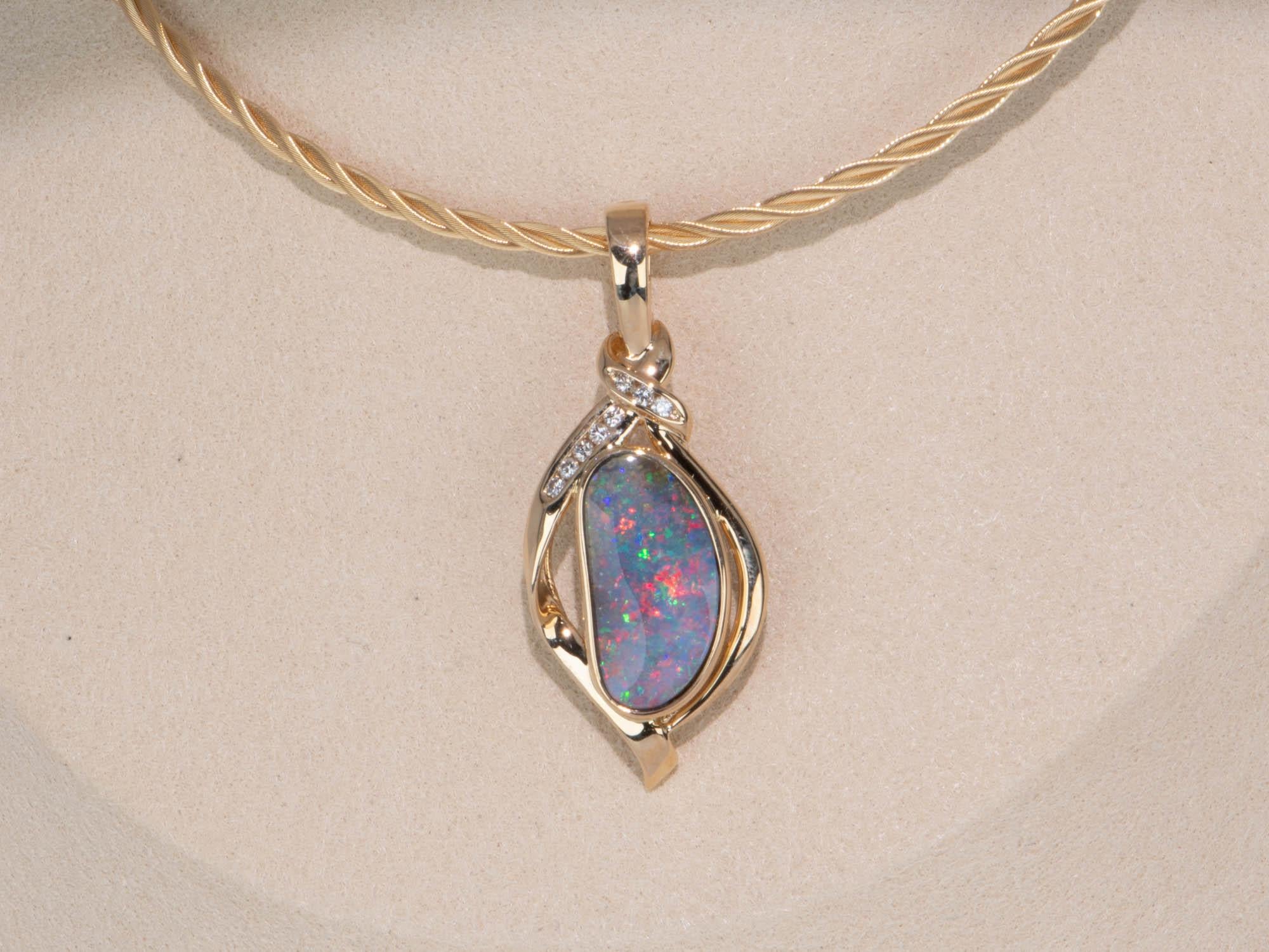 This stunning 5.85ct Australian Boulder Opal and Diamond Pendant will captivate you with its rainbow play of color and vibrant, bright colors. Set in lustrous 18K Gold, this pendant features a clip-on bail with a safety clasp so it can be added onto