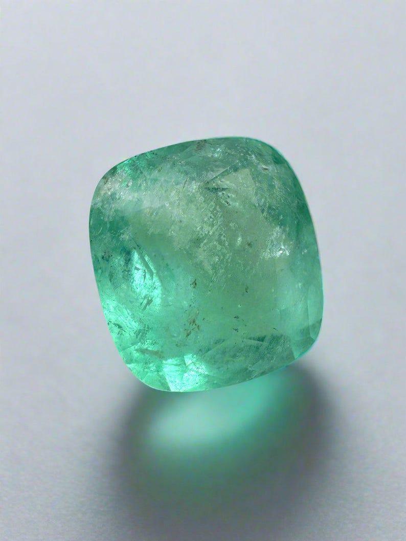 Stone: Emerald
Weight: 5.86-carats
Shape: Cushion Cut
Clarity: Semi-Transparent
Luster: Very Good
Color: Pastel Green
Measurements: 11.65mm x 10.63mm x 6.91mm
Geographic Origin: Colombia
Treatment: Natural, Oiling

Comments: Due to their growth