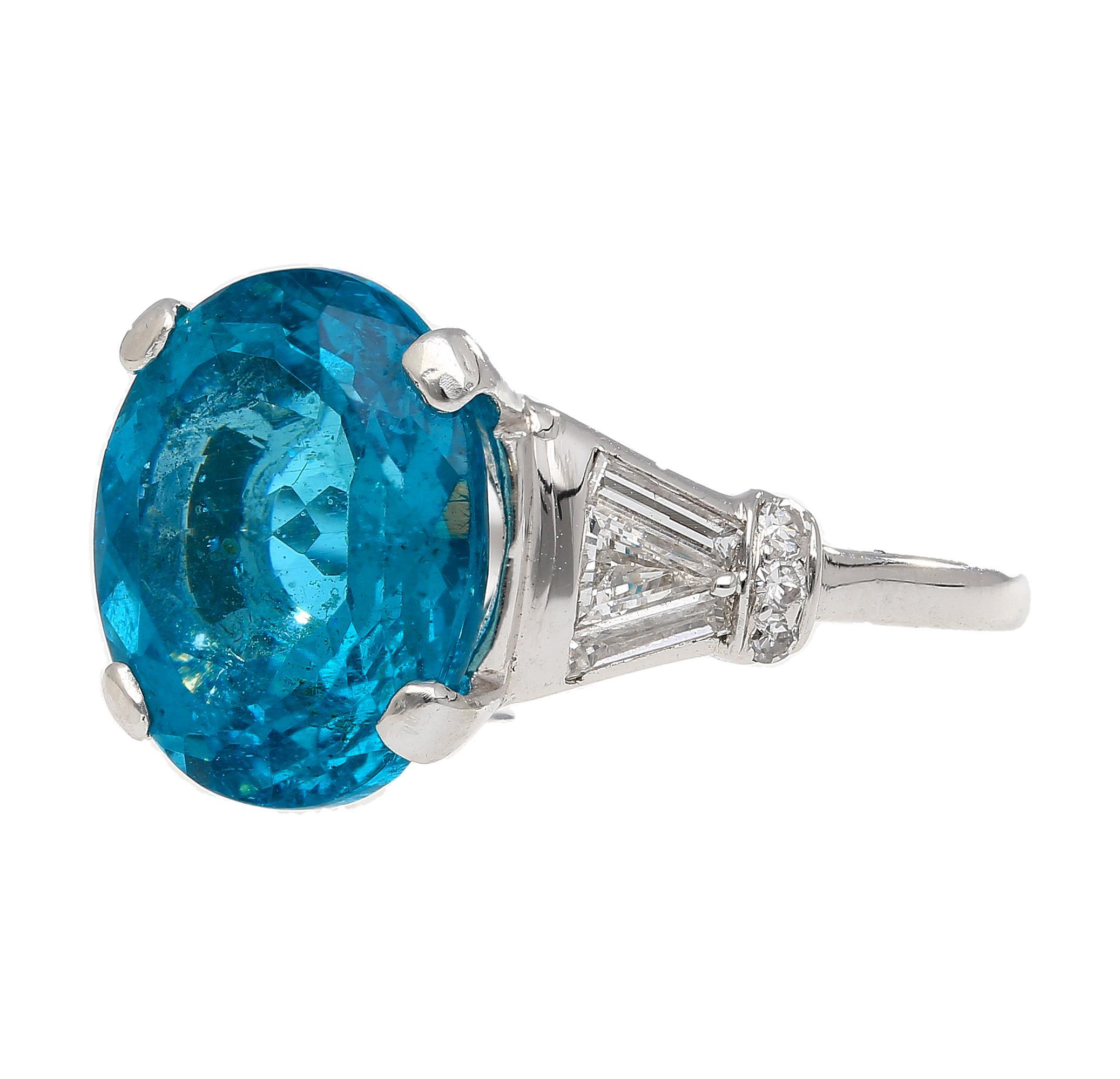 5.87 Carat Oval Cut Apatite and Diamond Platinum Cocktail Ring. The bright ocean blue apatite gemstone, sits in the center with a glistening eye-clean finish. The stone is prong-set within the platinum ring and the ring shank is tapered out and