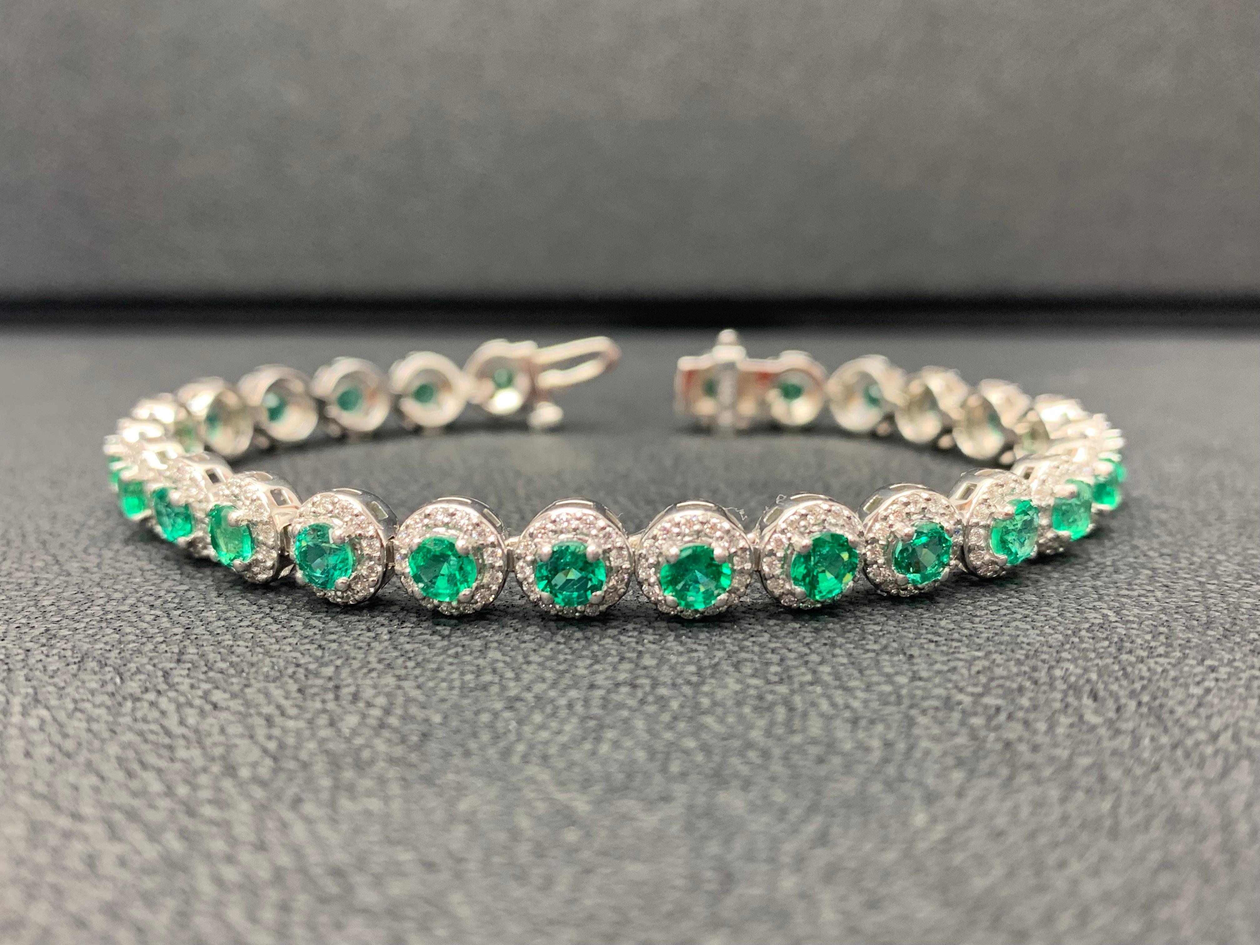 Ajoutez de la couleur à votre style avec ce magnifique bracelet en émeraude. Comprend 26 émeraudes de taille ronde entourées d'une seule rangée de diamants ronds étincelants dans une monture en halo. Les émeraudes et les diamants pèsent