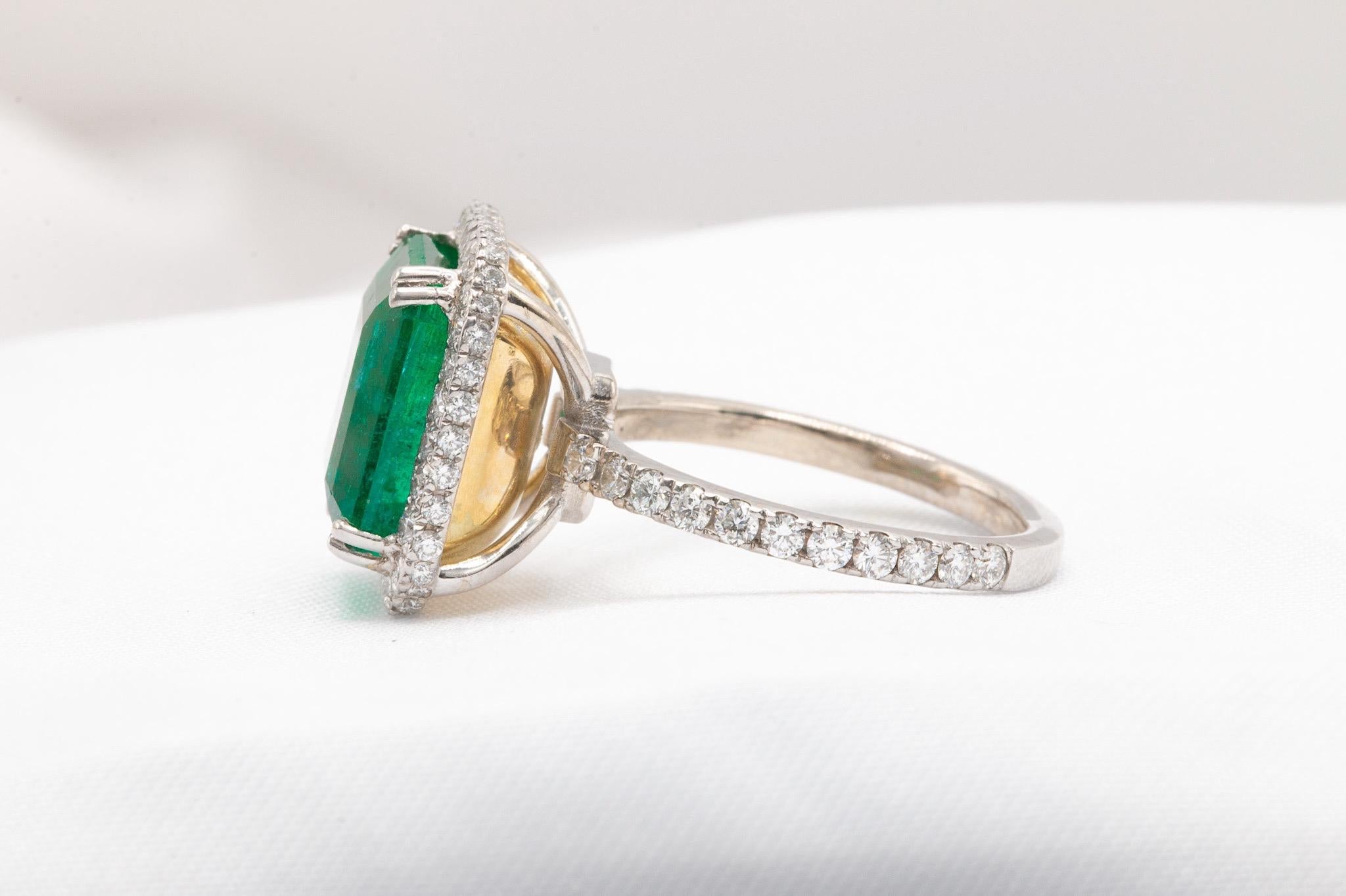 This exquisite ring showcases a 5.88-carat rich green Zambian emerald, accompanied by its original GIA certificate (#2231150026). Set in a unique hidden yellow gold basket, this gemstone is enhanced by 1 carat of sparkling round brilliant diamonds