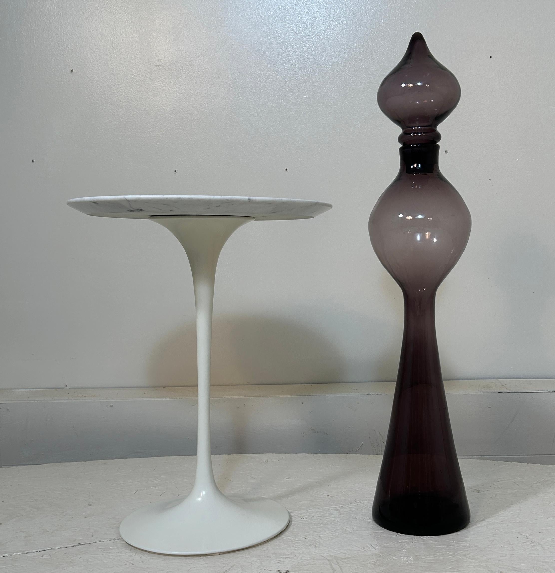 Prodotto solo nel 1959, questo decanter Lilac #588 di Wayne Husted è apprezzato per essere il primo modello di decanter in scala architettonica prodotto da Blenko, che ha portato ad altri. Presenta alcune inclusioni naturali dovute al processo di