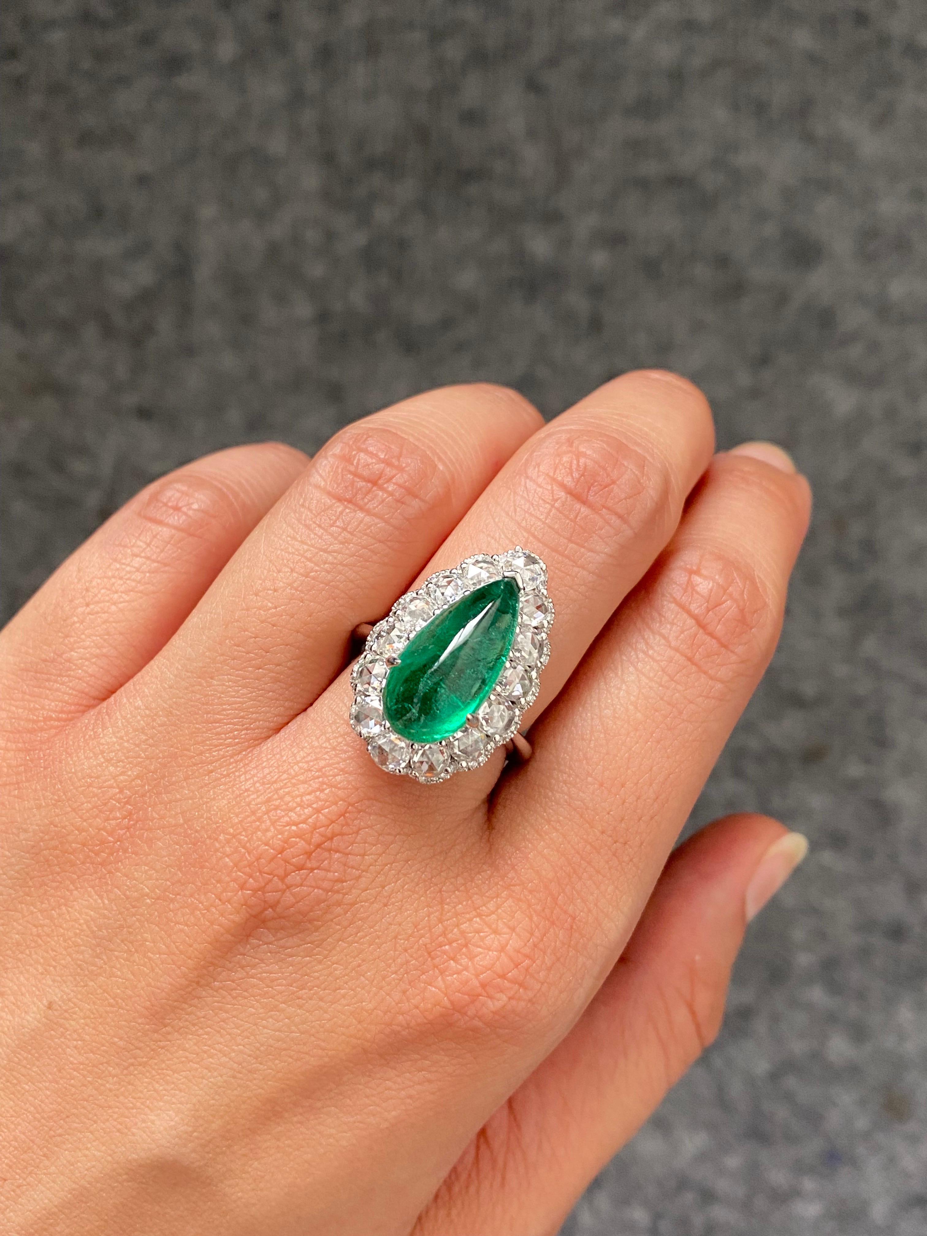 A stunning certified 5.89 carat, Zambian Emerald Cabochon center stone  with 1.92 carat VS quality rose cut Diamonds and 0.27 carat brilliant cut diamonds, set in 18K White Gold. The center stone has a beautiful luster, and vivid green color and