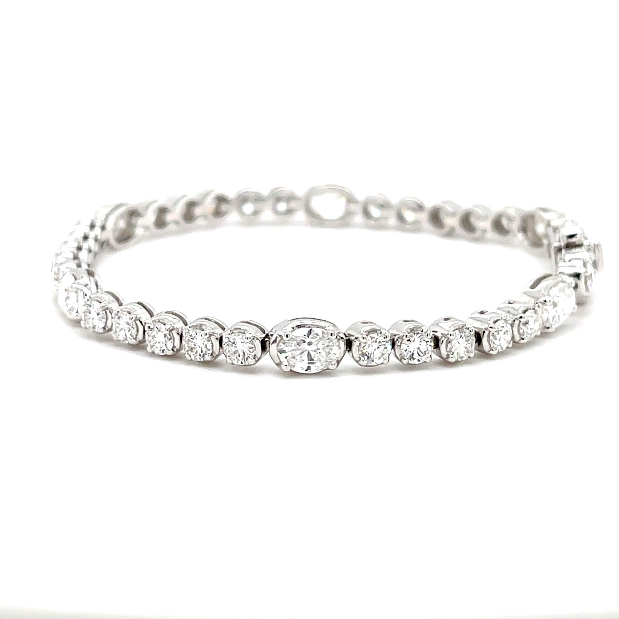 Introducing a touch of elegance with our 5.89-carat Oval & Round Natural Diamond Bracelet in 18K White Gold. The charm lies in its simplicity - six delicate oval diamonds, totaling 2.74 carats, complemented by a cluster of thirty round diamonds,