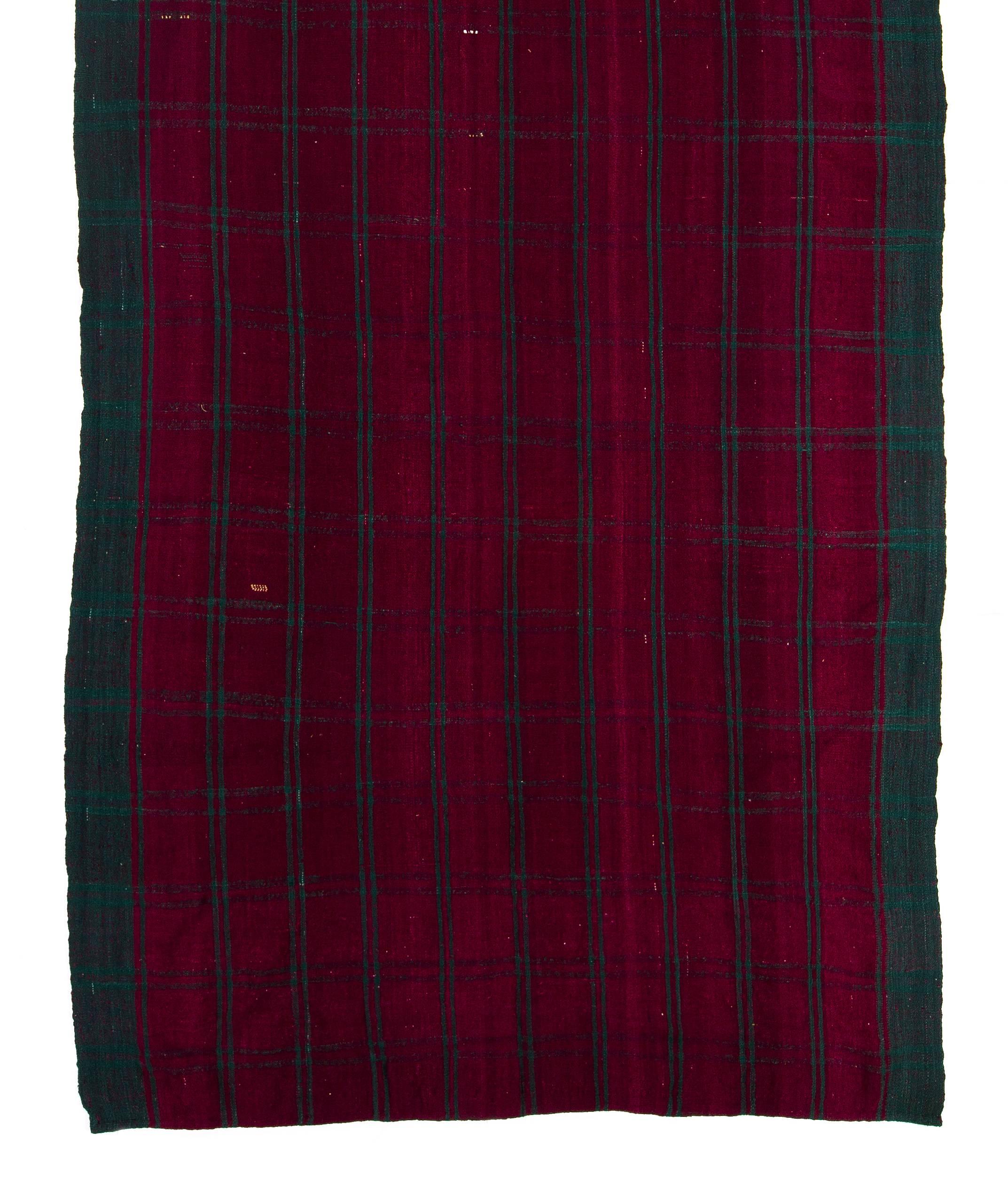 This beautiful and simple flat-woven rug is made of naturally dyed wool featuring a checkered design in dark ruby red and emerald green.
It was hand-woven by traditionally nomadic villagers of Central Turkey around mid-20th century. Lightweight,